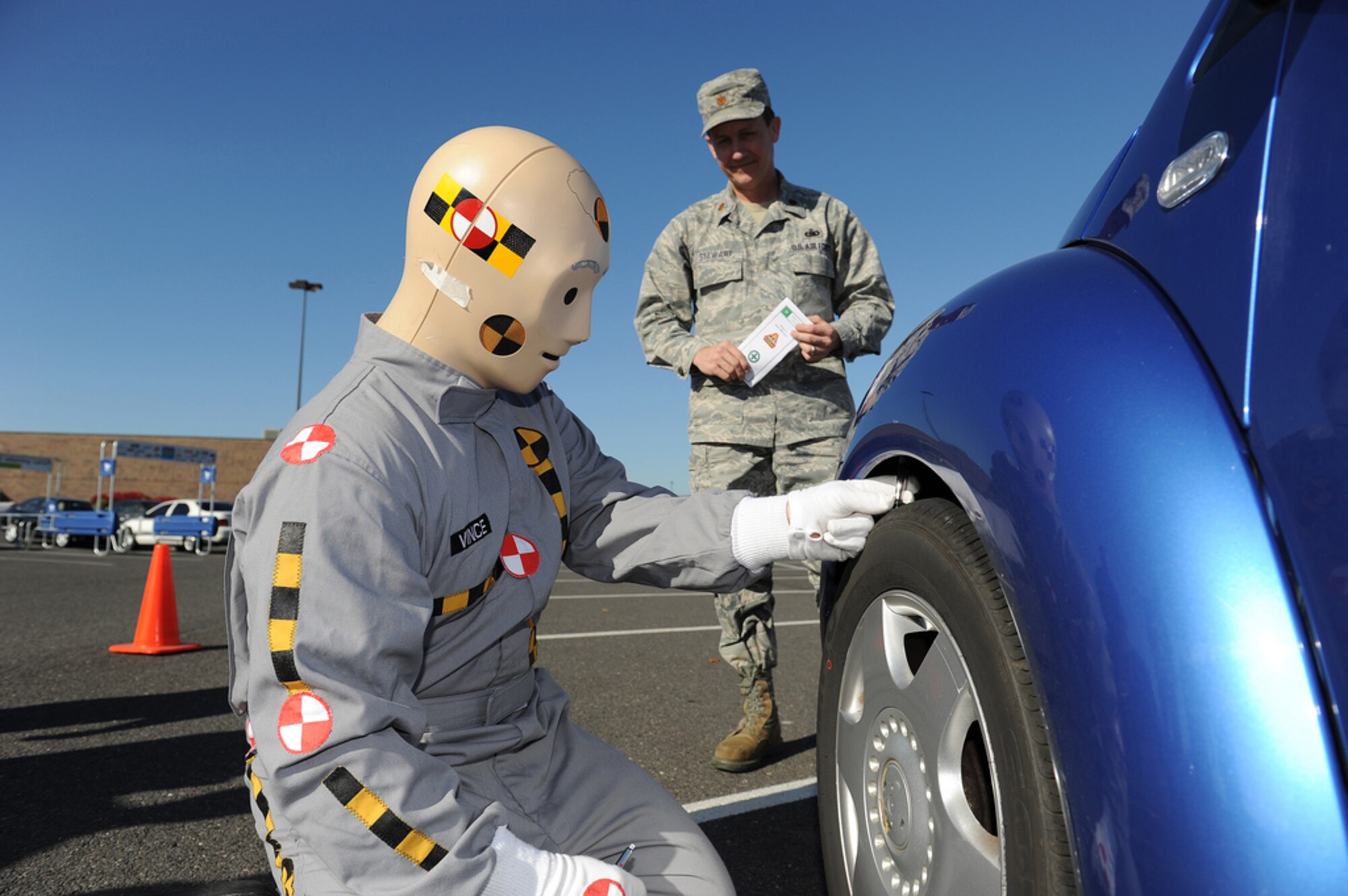 Crash test dummy “Vince,” played by Senior Airman Jared Lucci of the 87th Logistics Readiness Squadron, checks the car’s tire tread depth for Maj. Joe Stewart, 108th Mission Support Group executive officer, during the Winter Safety Campaign kickoff Nov. 9 at the Base Exchange. Volunteers performed tire inspections of vehicles and provided information to the community to familiarize them on how tire pressure and tread depth effect driving conditions during the winter. (U.S. Air Force Photo by Russ Meseroll/Released)
