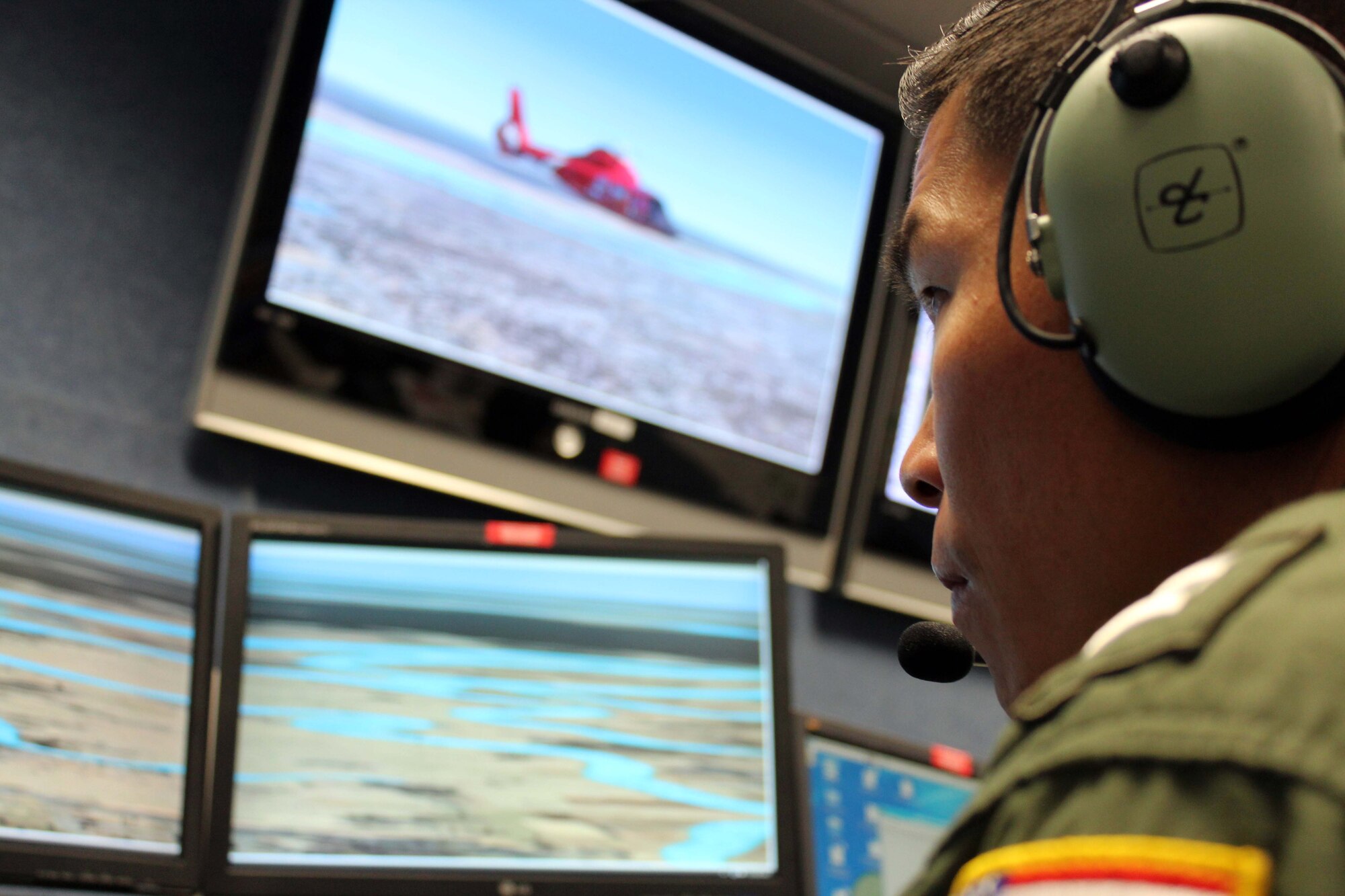 U.S. Coast Guard Lt. Al Lim, an HH-65 Dolphin helicopter pilot from the USCG Aviation Training Center in Mobile, Ala., flies an aircraft simulator during a joint and bi-national exercise executed through Air Forces Northern’s Distributed Mission Operations system Nov. 17. DMO is a system of inter-connected simulators that allows warfighters from across the U.S. and Canada to participate simultaneously in the same live scenario. (U.S. Air Force Photo by Angela Pope)
