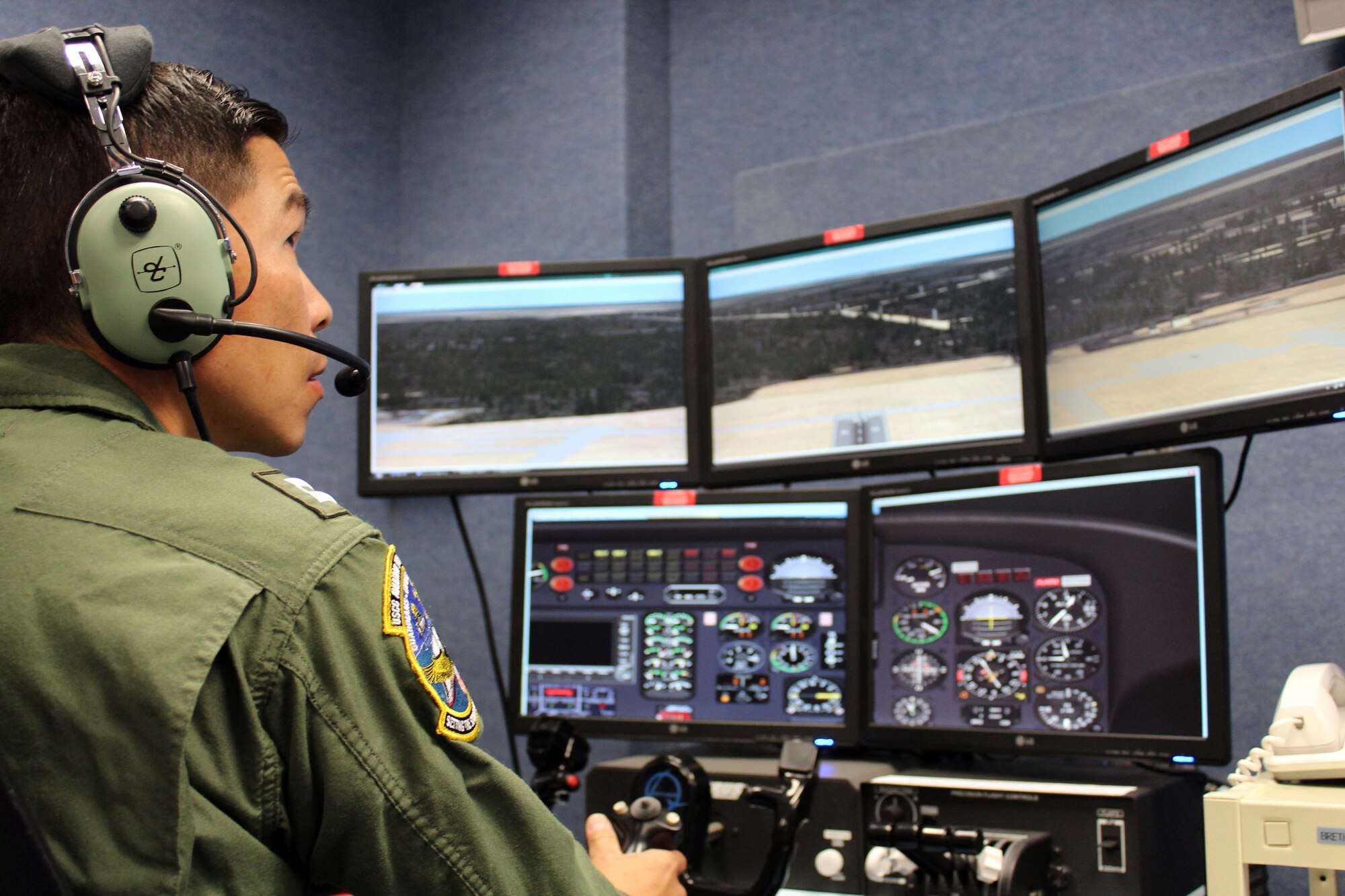 U.S. Coast Guard Lt. Al Lim, an HH-65 Dolphin helicopter pilot from the USCG Aviation Training Center in Mobile, Ala., flies an aircraft simulator during a joint and bi-national exercise executed through Air Forces Northern’s Distributed Mission Operations system Nov. 17. DMO is a system of inter-connected simulators that allows warfighters from across the U.S. and Canada to participate simultaneously in the same live scenario. (U.S. Air Force Photo by Angela Pope)