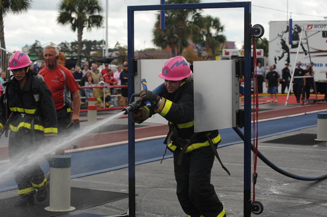 Senior Airman Jessica Condon, (right) a firefighter from the Air Force Academy, Colo., tries to knock down a target with a stream of water during the World Firefighter Combat Challenge XX at Myrtle Beach, S.C., Nov. 17, 2011. Both Condon and Elaine Perkins (far left) are members of the two-time world champion Fire Fembots team, which is a combined team of firefighters from the Air Force Academy and Colorado Springs, Colo., fire departments. (U.S. Air Force photo/John Van Winkle)