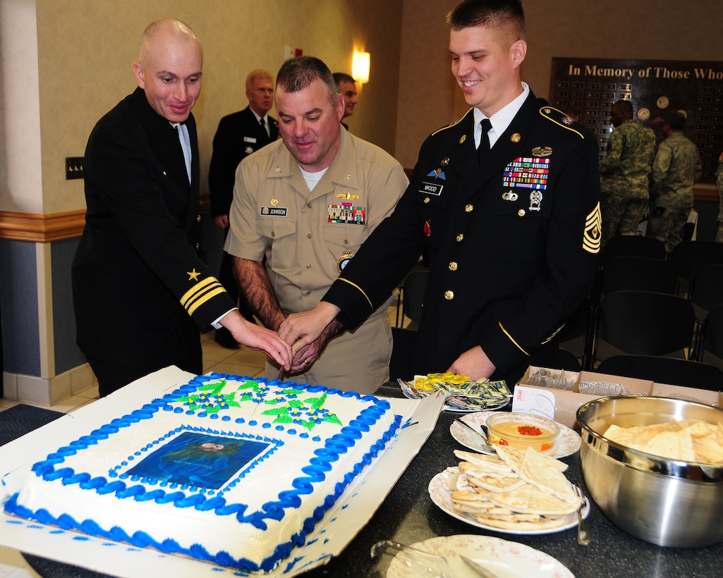 Buffalo Military Entrance Processing Station Commander Navy Lieutenant Commander Keith Archibald, United States Military Entrance Processing Command Commander Navy Captain Eric W. Johnson, and Buffalo MEPS Senior Enlisted Advisor 1st Sgt. Dwayne A. Wood slice some cake after the Warrior Board dedication ceremony on Nov. 17, 2011. Unveiling of the Warrior Board at the Buffalo MEPS, Niagara Falls Air Reserve Station, NY honored those military members who processed through MEPS, were from Western New York and who gave the ultimate sacrifice. (U.S. Air Force photo by Peter Borys)