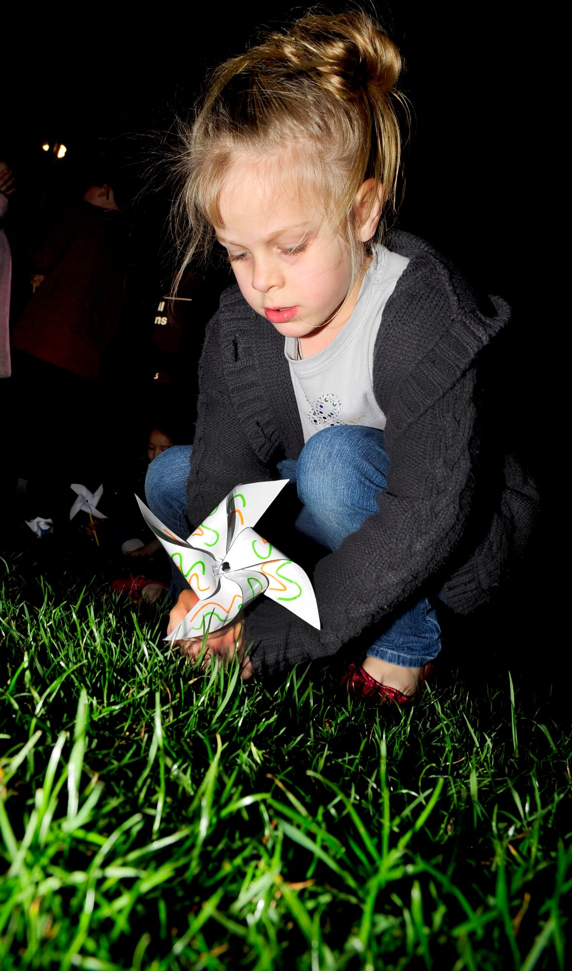 RAF MILDENHALL, England – Riley Robertson, 5, daughter of Michele Robertson, 100th Force Support Squadron, presses a ‘Pinwheels for Peace’ into the ground as part of a National World Peace Day event held at the RAF Mildenhall Youth Center Nov. 17, 2011. According to their website ‘Pinwheels for Peace’ is an art installation project started in 2005 by two Art teachers, Ann Ayers and Ellen McMillan, as a way for their students to express their feelings about what’s going on in the world and in their lives.  The event was held by the youth center to support military troops, hope for their safe return and raise awareness of peace in many different situations. (U.S. Air Force photo/Senior Airman Ethan Morgan)