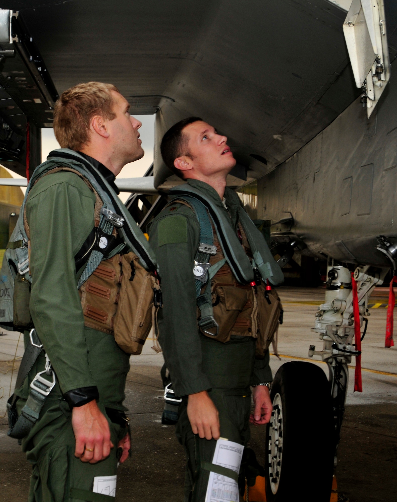 ROYAL AIR FORCE LAKENHEATH, England - U.S. Air Force Maj. Mike Conrad, 493rd Fighter Squadron pilot, (left) checks aircraft forms as Swedish Air Force Capt Fredrik Bergstrom, 211th Fighter Squadron, watches prior to take-off, Nov. 17, 2011. This is Bergstrom's first time ever in a foreign aircraft.Members from the SAF and the 48th Fighter Wing trained together to increase their interoperability and gather experience with foreign aircraft. (U.S. Air Force photo by Senior Airman Tiffany M. Deuel)