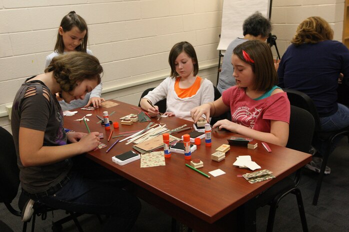 A group of military children craft gift tags and card holders during the Christmas Card workshop hosted by Marine Corps Community Services at Harriotte B. Smith Library aboard Marine Corps Base Camp Lejeune, recently. Two workshops were offered, both of which were fully booked.