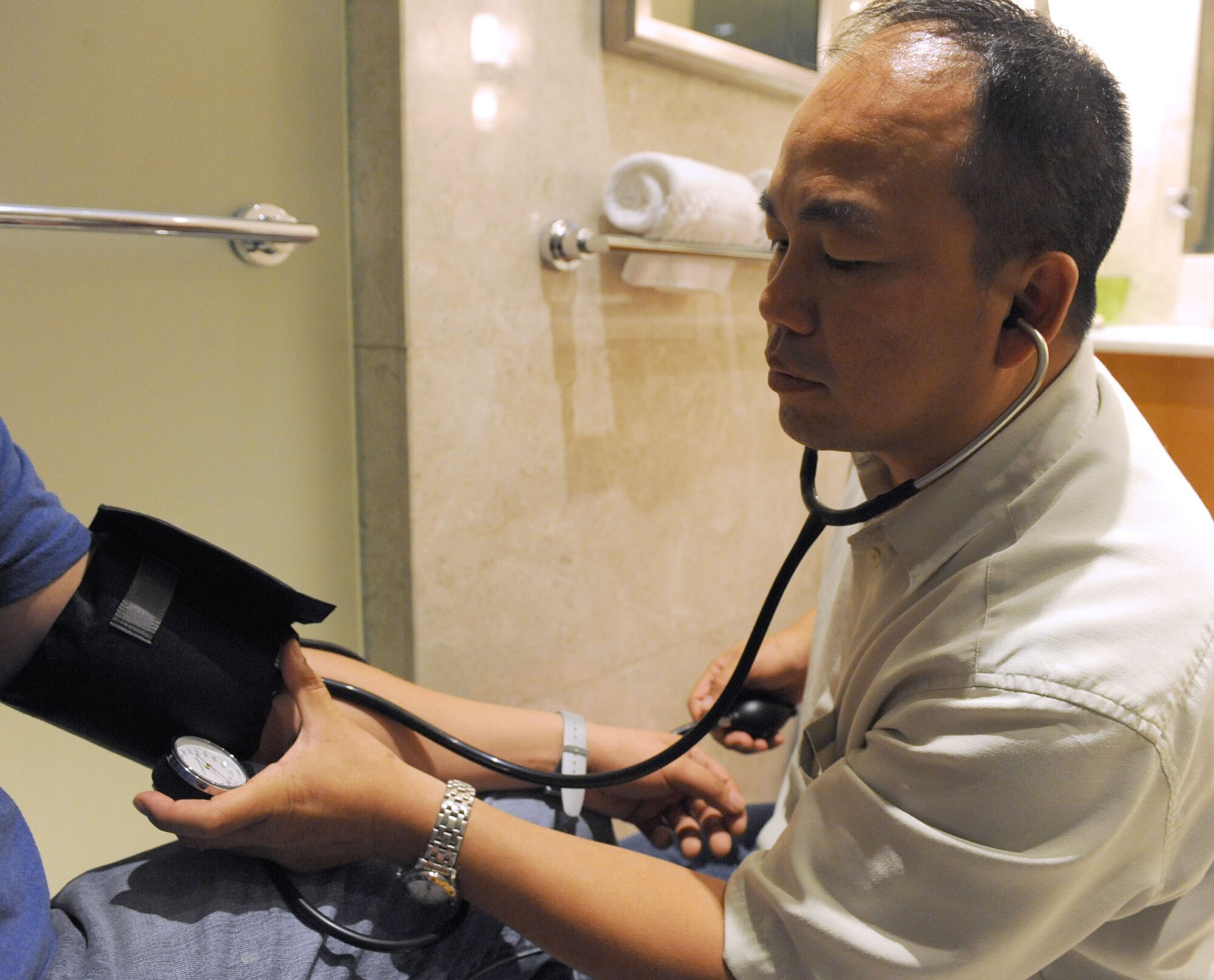 Lt. Col. (Dr.) Kai-Wood Ma, the deputy group commander and the chief of aerospace medicine for the 380th Expeditionary Medical Group, takes the blood pressure of a sick-call patient during the 2011 Dubai Airshow, Nov. 12, 2011. This is the first time the 380th Air Expeditionary Wing has provided sick-call support for the international event, which was held at the Dubai International Airport Nov. 13-17. Ma also worked with the emergency management team to determine hospitals that could treat the Department of Defense personnel attending the show if needed in an emergency. The U.S. military is participating in the 2011 Dubai Airshow to nurture partnerships in the region and foster a shared commitment to security. Ma is originally from Hong Kong and is deployed to the 380th AEW from Joint Base Pearl Harbor-Hickam, Hawaii. (U.S. Air Force photo/Master Sgt. Chance Babin)