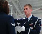 Senior Airman William Horne of the Eglin Air Force Base Honor Guard presents the colors during a recent flag folding ceremony for a retiring reservist at Duke Field, Fla.   The Eglin Honor Guard routinely performs traditional honors for Duke Field ceremonies as part of their overall support to regional military units.  (U.S. Air Force photo/Dan Neely)