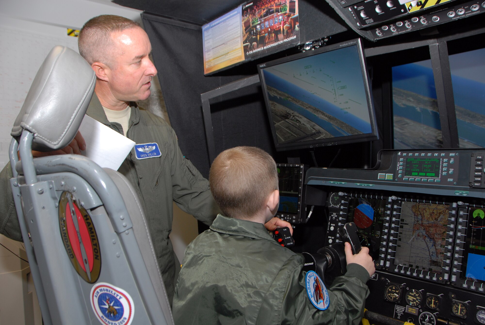 Donovan Benzin became a Guardsman for a day at the 107th Airlift Wing, Niagara Falls ARS. Lt. Col. Gregory Miller shows Donovan how to fly a C-130 aircraft on a simulator.