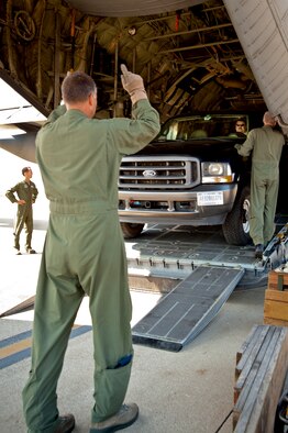 Senior Master Sgt. John Siebert, a loadmaster from the 165th Airlift Squadron, guides a truck and trailer packed with rescue gear onto a Kentucky Air Guard C-130 as Airmen prepare to deploy Sept. 28, 2011, from Louisville, Ky., to Joint Base McGuire-Dix-Lakehurst, N.J., where they were expected to stage for rescue operations in the aftermath of Hurricane Irene. The deployment was called off just prior to the Airmen's departure when damage from Irene was found to be less extensive than anticipated. (U.S. Air Force photo by Maj. Dale Greer)