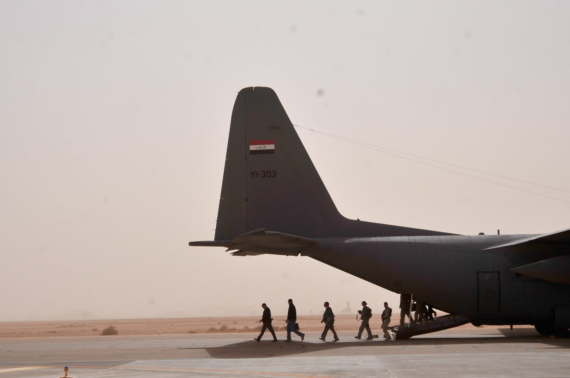 Members of the Iraqi Air Force, Ministry of Defense, U.S. military, Iraqi and Pan-Arab media depart an Iraqi air force C-130E in Western Iraq on Nov. 8, 2011. The group attended a press conference hosted by staff Lt. Gen. Anwer Amin, the commander of the Iraqi air force. Amin told the Iraqi and Pan-Arab media Iraq's purchase of 18 F-16C Fighting Falcons, for their future air defense, will encourage and strengthen the strategic partnership between the U.S. and Iraq. He conducted the press conference in front of an F-16 static display provided by the 125th Expeditionary Fighter Squadron, an Oklahoma Air National Guard unit providing top cover in Iraq for U.S. service members. When the Iraqi F-16s are delivered, most likely sometime in late 2014 or 2015, Iraq will have the most advanced multi-role fighter aircraft in the world. (U.S. Air Force photo/Master Sgt. Cecilio Ricardo)