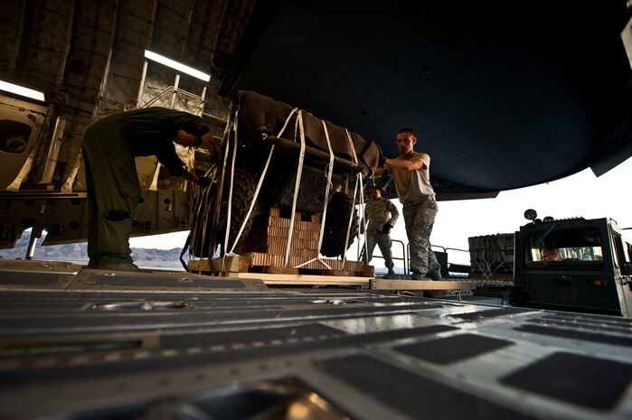 U.S. Air Force Airmen push cargo on to a C-17 Globemaster during the Mobility Air Forces Exercise on Nov. 15, 2011, at Nellis Air Force Base, Nev. The C-17 and C-130 Hercules cargo aircraft will assemble in aerial formations over the Nevada Test and Training Range to conduct air and ground operations as part of the bi-annual U.S. Air Force Weapons School MAFEX. (U.S. Air Force photo by Airman 1st Class George Goslin/Released)