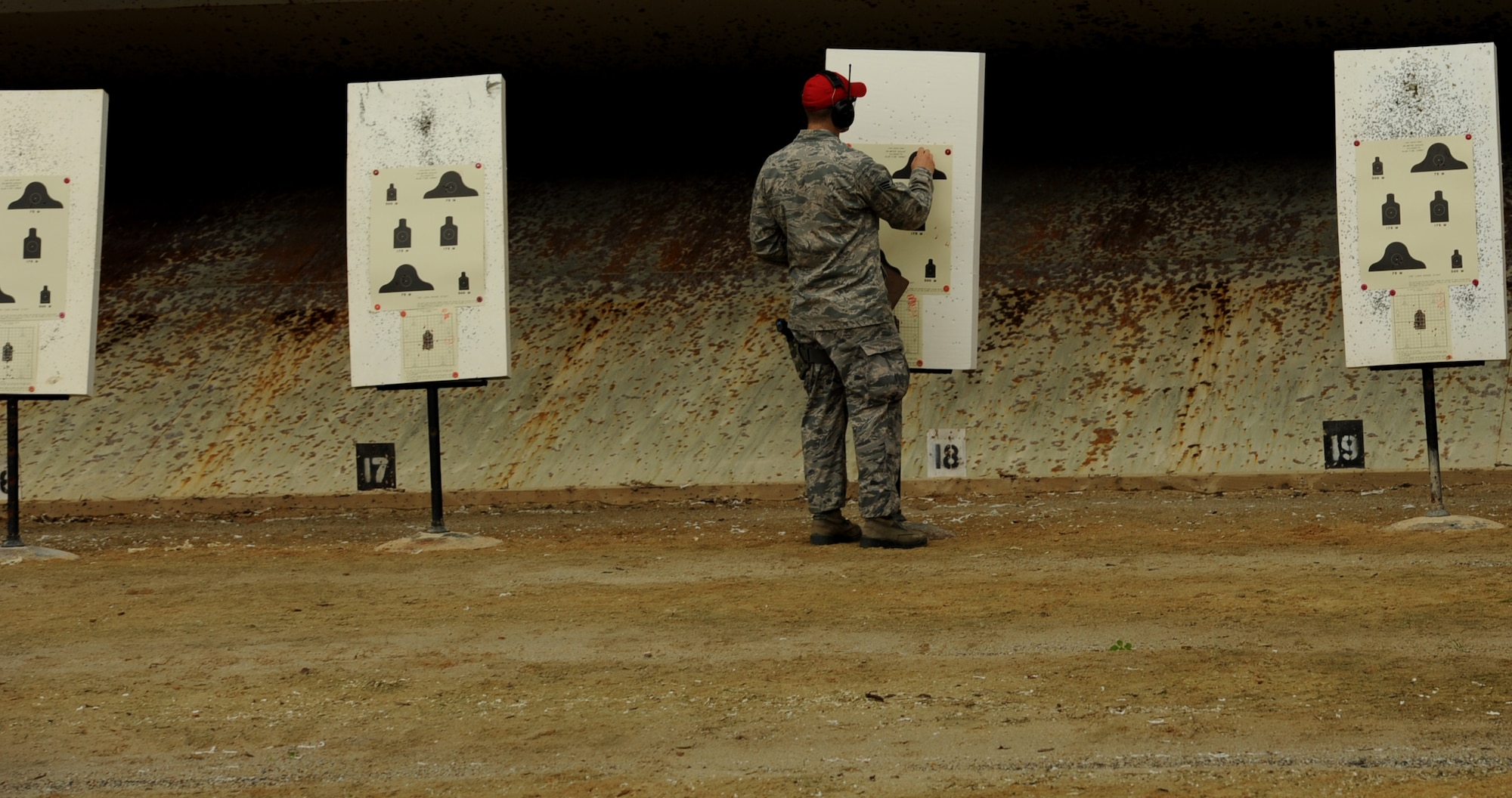 U.S. Air Force Senior Airman Skyler Thacker, 18th Security Forces Squadron combat arms instructor, indicates a qualifying Airman's accuracy during the new weapons qualifications course at Kadena Air Base, Japan, Nov. 8, 2011. Beginning Dec.1, all Airmen are required to perform in the modernized rifle qualification course which comprises movement while engaging targets to better train and equip Airmen for today's fight. (U.S. Air Force photo by Senior Airman Jarvie Z. Wallace/Released)
