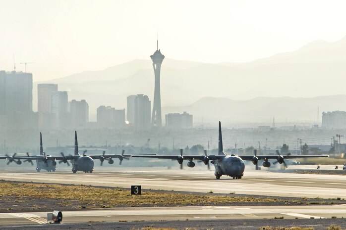 A three ship formation of U.S. Air Force C-130 Hercules prepare to take off from Nellis Air Force Base, Nev. to participate in the Mobility Air Forces Exercise Nov. 16, over the Nevada Test and Training Range. The U.S. Air Force Weapons School holds MAFEX twice a year to test the ability of C-17 Globemaster and C-130 Hercules aircrews from Air Force bases around the world to join together in a formation at a specific time and location to insert ground forces and equipment anywhere in the world. (U.S. Air Force photo by Lawrence Crespo/Released)