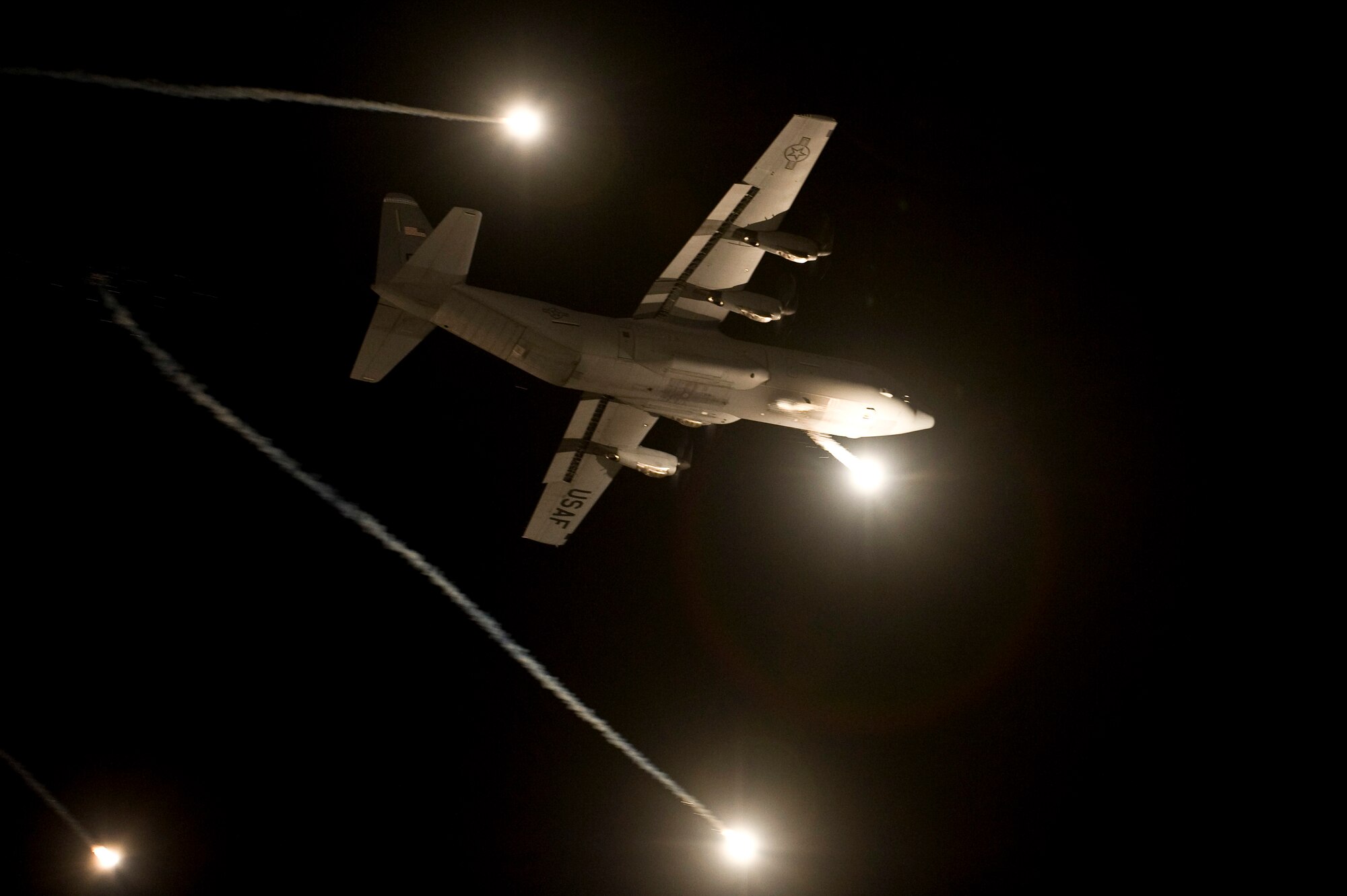 A U.S. Air Force C-130 Hercules performs evasive countermeasures by launching flares during a Mobility Air Forces Exercise Nov. 16, over the Nevada Test and Training Range. The U.S. Air Force Weapons School holds MAFEX twice a year to test the ability of C-17A Globemaster III and C-130 Hercules aircrews from Air Force bases around the world to join together in a formation at a specific time and location to insert ground forces anywhere in the world. The 820th RED HORSE Airborne Flight conducted airdrops over the NTTR. (U.S. Air Force photo by Senior Airman Brett Clashman/Released)
