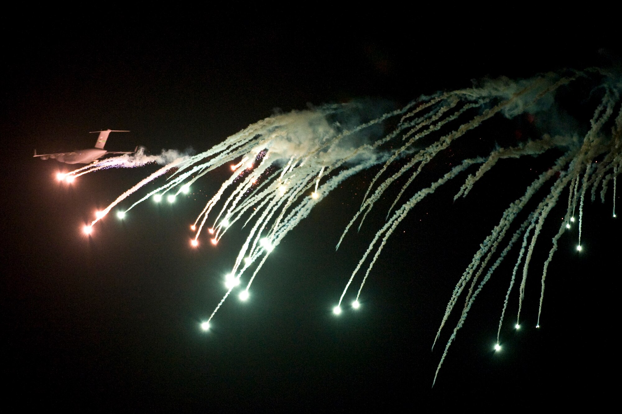 A U.S. Air Force C-17 Globemaster III performs evasive countermeasures by launching flares during a Mobility Air Forces Exercise Nov. 16, over the Nevada Test and Training Range. The U.S. Air Force Weapons School holds MAFEX twice a year to test the ability of C-17A Globemaster III and C-130 Hercules aircrews from Air Force bases around the world to join together in a formation at a specific time and location to insert ground forces anywhere in the world. The 820th RED HORSE Airborne Flight conducted airdrops over the NTTR. (U.S. Air Force photo by Senior Airman Brett Clashman/Released)
