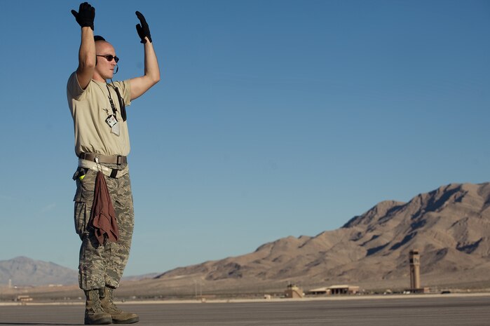 U.S. Air Force Staff Sgt. Kevin Byrne, 317th Aircraft Maintenance Squadron crew chief, Dyess Air Force Base, Texas, marshals out a C-130 Hercules during Mobility Air Forces Exercise Nov. 16, 2011, at Nellis Air Force Base, Nev. The U.S. Air Force Weapons School holds MAFEX twice a year to test the ability of C-17A Globemaster III and C-130 Hercules aircrews from Air Force bases around the world to join together in a formation at a specific time and location to insert ground forces anywhere in the world.(U.S. Air Force photo by Staff Sgt. Christopher Hubenthal)