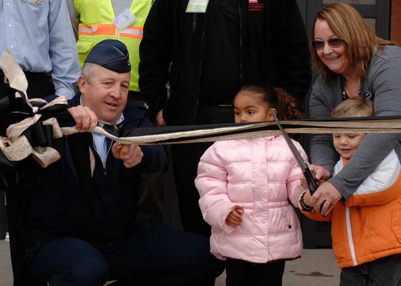 Lt. Col Dave Piech, 27th Special Operations Mission Support Group commander, assisted by, Denise Vanderwarker, Airman and Family Services flight chief, Dalton McDonald and Kiyah Morris, cut the ribbon at the grand opening of the new Child Development Center at Cannon Air Force Base, N.M., Nov.21, 2011. The ceremonial ribbon was cut in the special operations style by using a special operations dagger. (U.S. Air Force photo by Airman 1st Class Ericka Engblom)