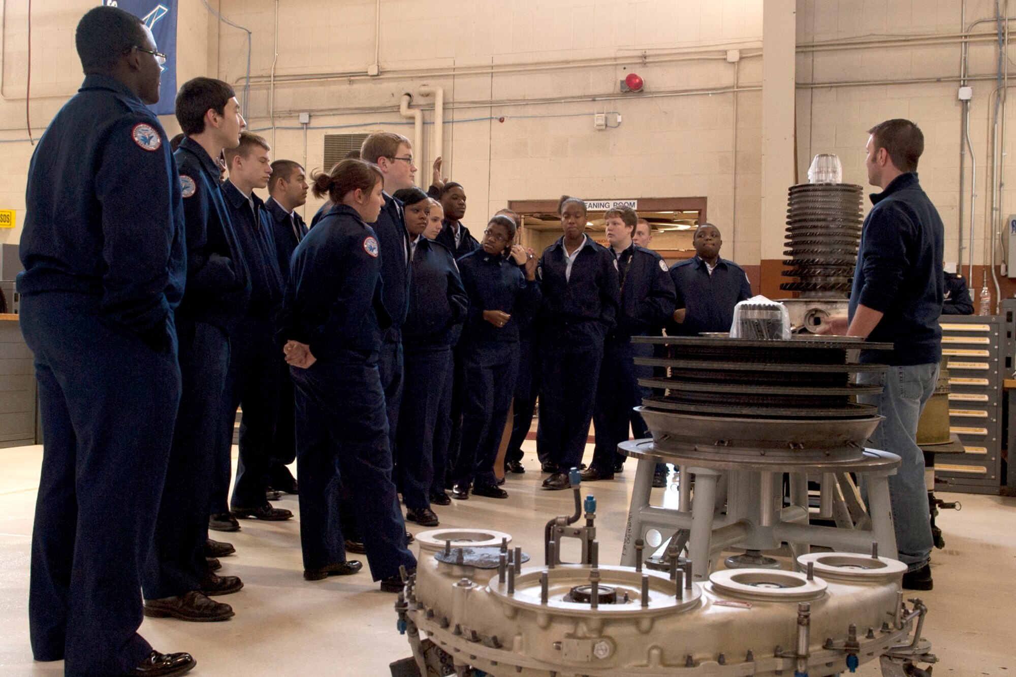 Cadets from the Marshall High School Junior Reserve Officers' Training Corps (JROTC) look on as U.S. Air Force Staff Sgt. Beau Traweek, 917th Maintenance Squadron jet engine mechanic, talks about the disassembly and inspection of an engine for the A-10 Thunderbolt II. The cadets visited Barksdale and were given a tour of an A-10 and the 917th Operations Support Squadron aircrew flight equipment shop. (U.S. Air Force photo by Master Sgt. Greg Steele/Released)