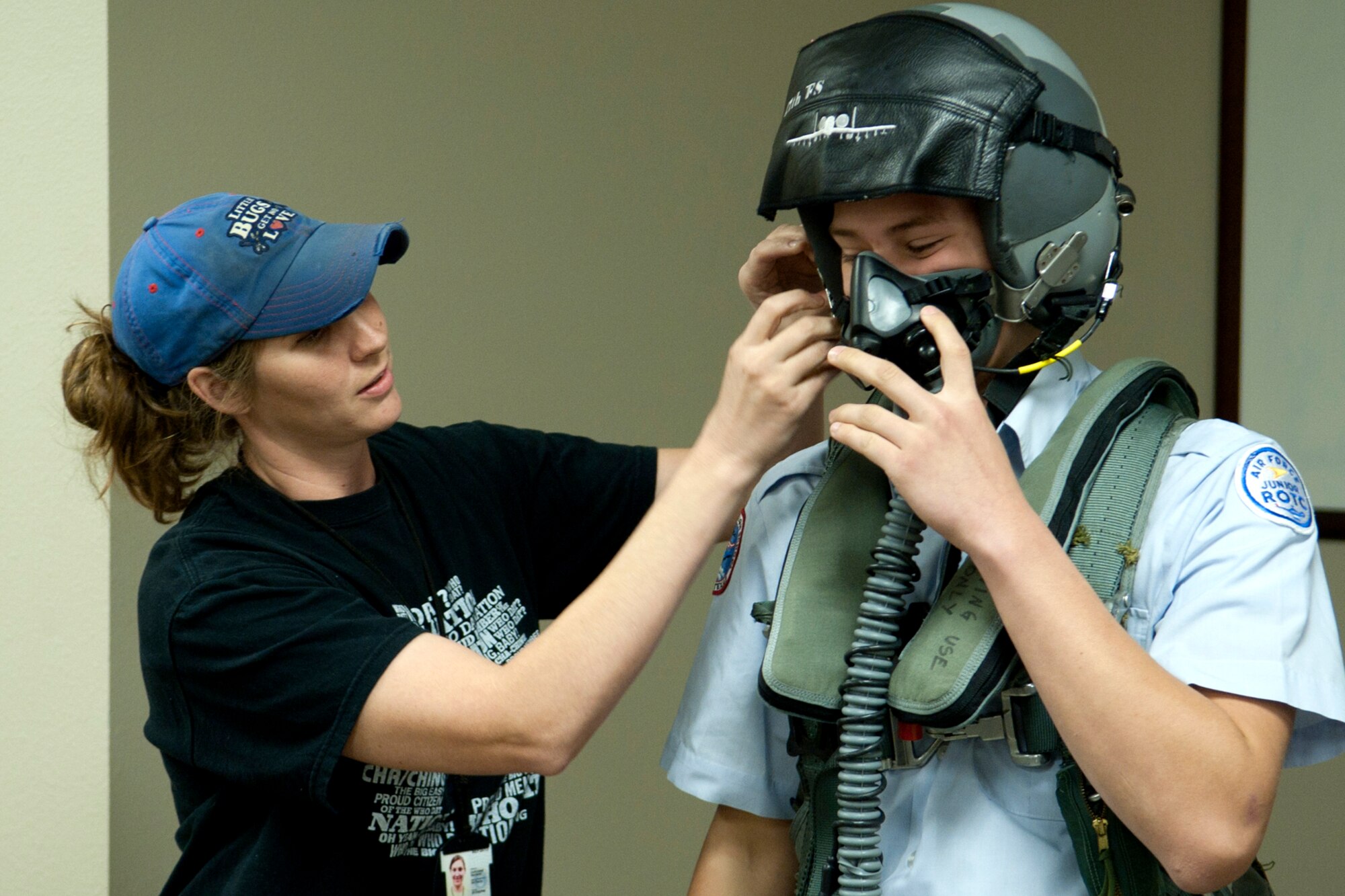 U.S. Air Force Master Sgt. Andre Menard, 917th Operations Support Flight aircrew flight equipment (AFE) specialist, helps put a pilot's helmet on Bryce Wells, Marshall High School Junior Reserve Officers' Training Corps (JROTC) cadet, Barksdale Air Force Base, La., Nov. 18, 2011. The JROTC visited Barksdale and was given a hands-on tour of the AFE shop. (U.S. Air Force photo by Master Sgt. Greg Steele/Released)