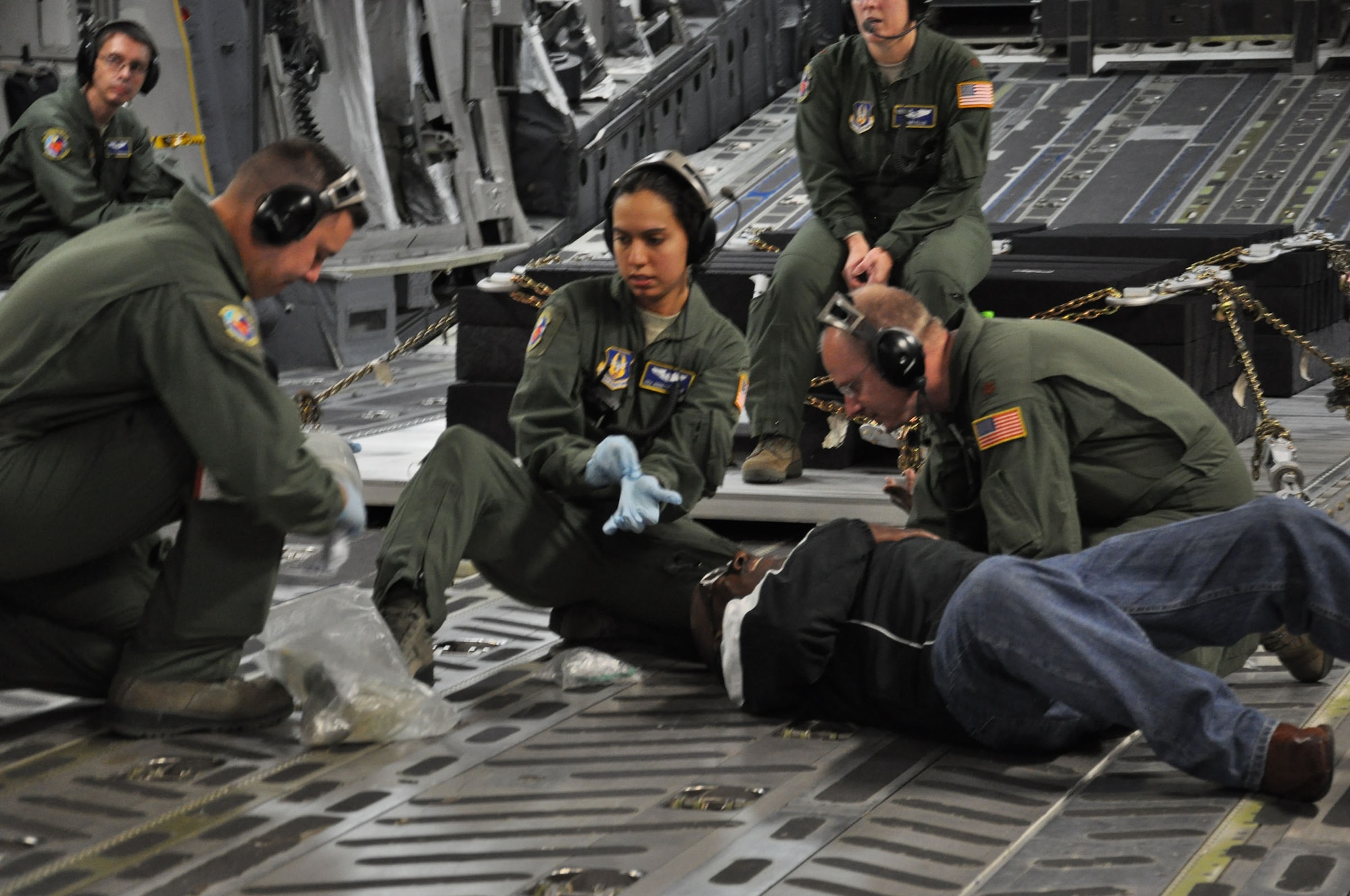 WRIGHT-PATTERSON AIR FORCE BASE, Ohio – (from left to right) Medical technicians Staff Sgt. Joseph Valenzuela and Senior Airman Ginnette Lykins, both from the 445th Aeromedical Evacuation Squadron along with Maj. Chad Corliss, 94th Aeromedical Evacuation Squadron flight nurse, tend to James Chappel, OG&E Electric Service Company, who was role playing a heart attack patient during a training scenario Nov. 17. Chappel, who was representing Tinker Air Force Base, Okla., and 20 other Air Force Materiel Command Community Liaison Program members enjoyed an orientation flight aboard a 445th Airlift Wing C-17 Globemaster III. (U.S. Air Force photo/Stacy Vaughn)