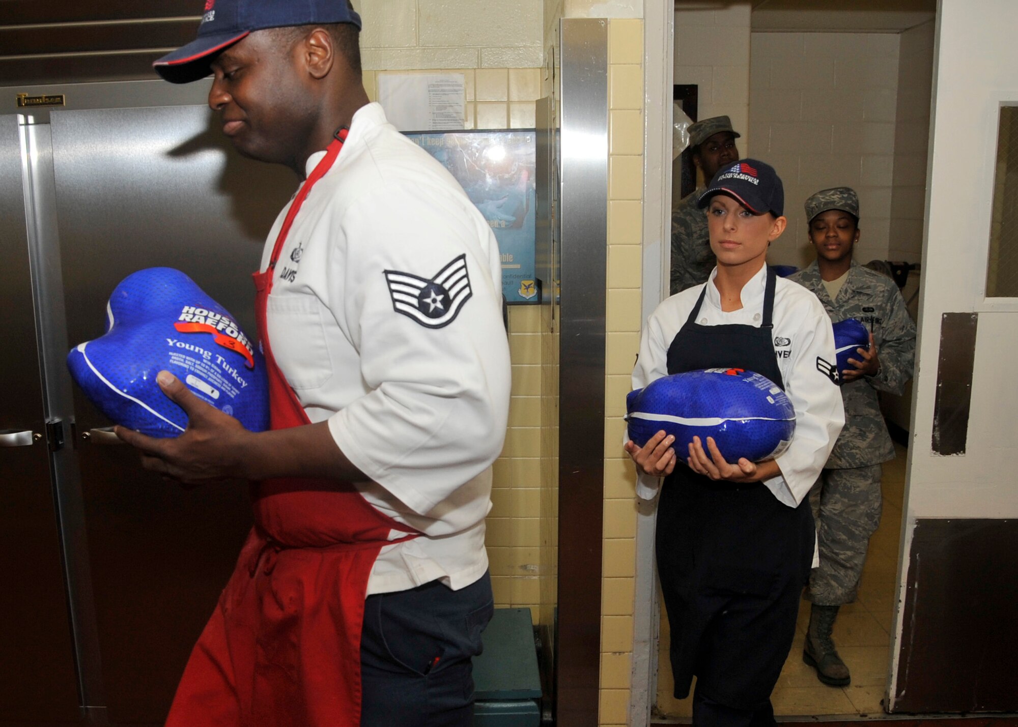 Members of the 436th Force Support Squadron carry turkeys out of the freezer before preparing them, Nov. 21, 2011, at the Patterson Dining Facility, Dover Air Force Base, Del. Proper preparation of food is paramount to a safe and healthy Thanksgiving dinner. (U.S. Air Force photo by Tech. Sgt. Chuck Walker)
