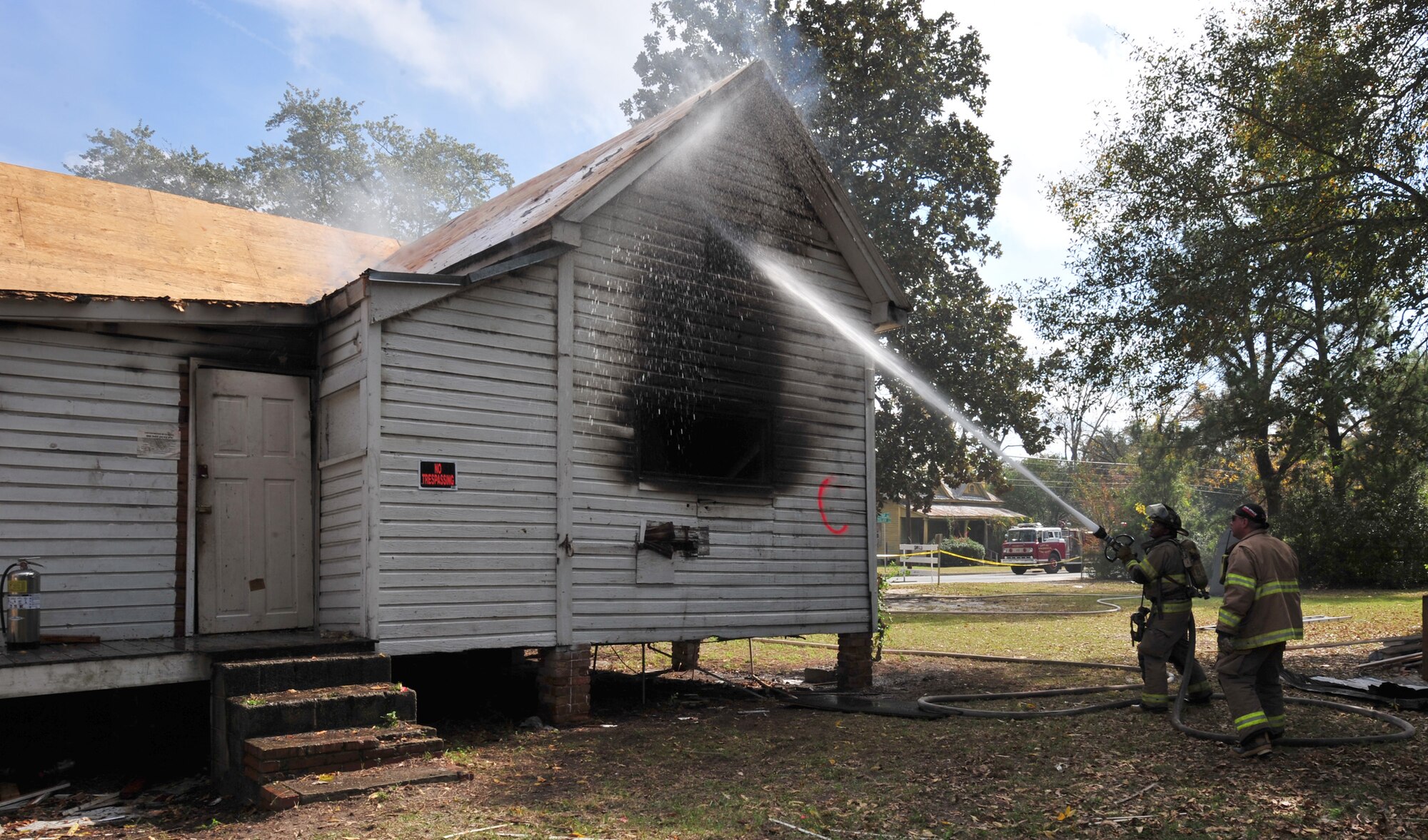 Cory Williams, Valdosta firefighter, helps put out a house fire during live-fire training in Valdosta, Ga., Nov. 15, 2011. Since the house was used for a live fire rather than a controlled fire, many safety precautions had to be considered. Various danger factors gave the training participants a feel for what to expect during an actual house fire. Williams has been with the Valdosta Fire Department for three years. (U.S. Air Force photo by Staff Sgt. Stephanie Mancha/Released)