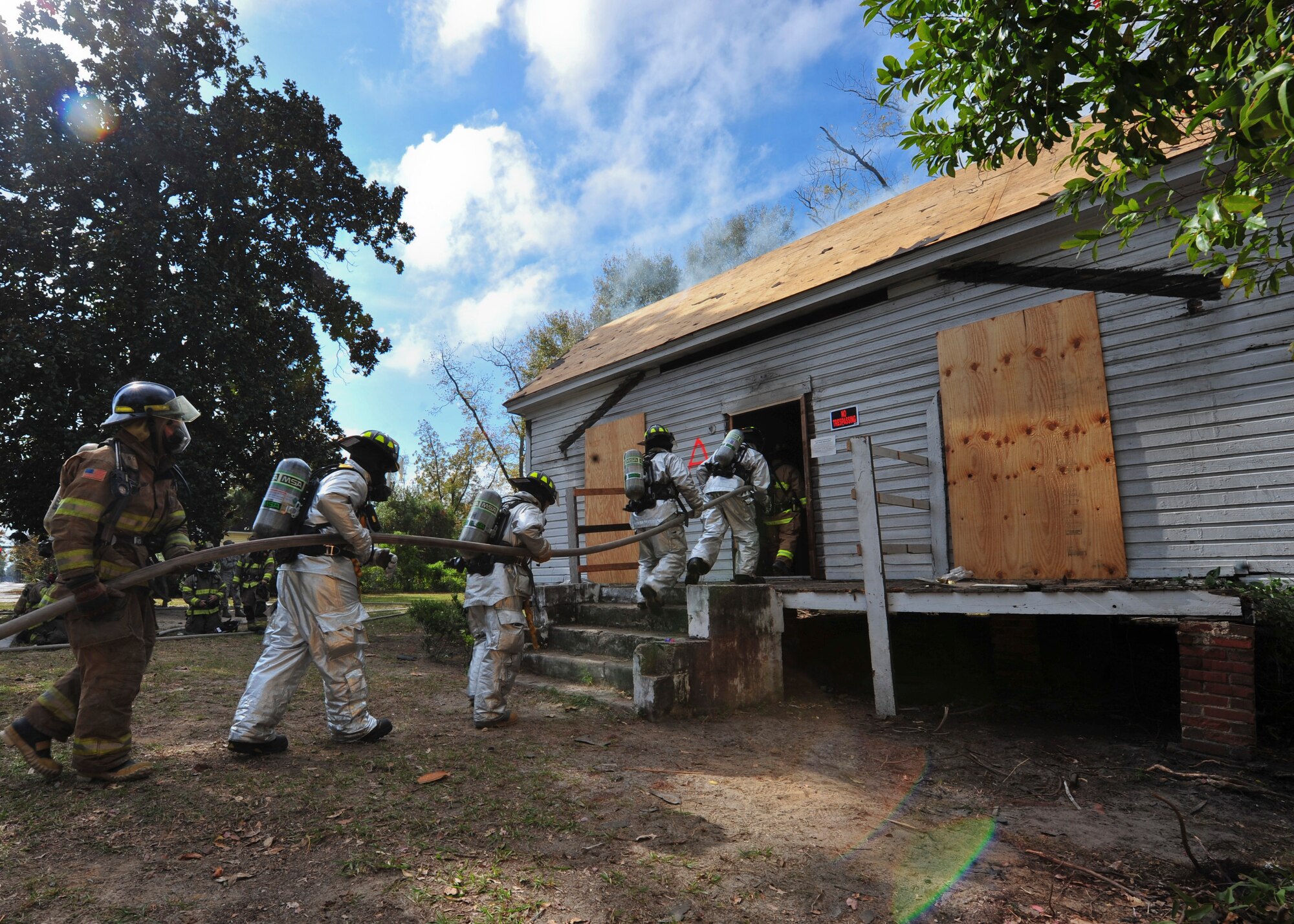 Firefighters from the 23rd Civil Engineer Squadron from Moody Air Force Base, Ga., and Valdosta Fire Department enter a burning house during live-fire training in Valdosta, Ga., Nov. 15, 2011. The house was scheduled for demolition and the VFD was able to help tear it down while getting a chance to train. The property is planned to be used to build a house for Habitat for Humanity. (U.S. Air Force photo by Staff Sgt. Stephanie Mancha/Released) 