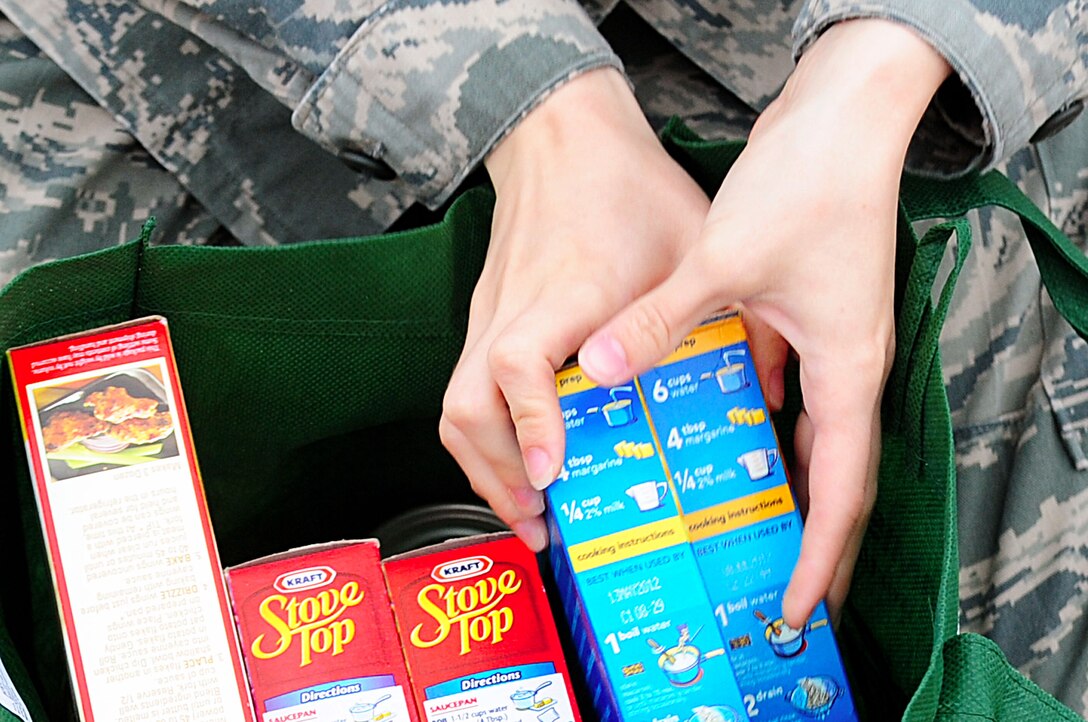 U.S. Air Force Airman 1st Class Sheila Hottle, 30th Intelligence Squadron imagery analyst, organizes an Operation Warmheart bag at Langley Air Force Base, Va., Nov. 21, 2011. Operation Warmheart is a non-profit organization that was established to distribute charitable funds to Langley families throughout the year. (U.S. Air Force photo by Airman 1st Class Kayla Newman/Released)