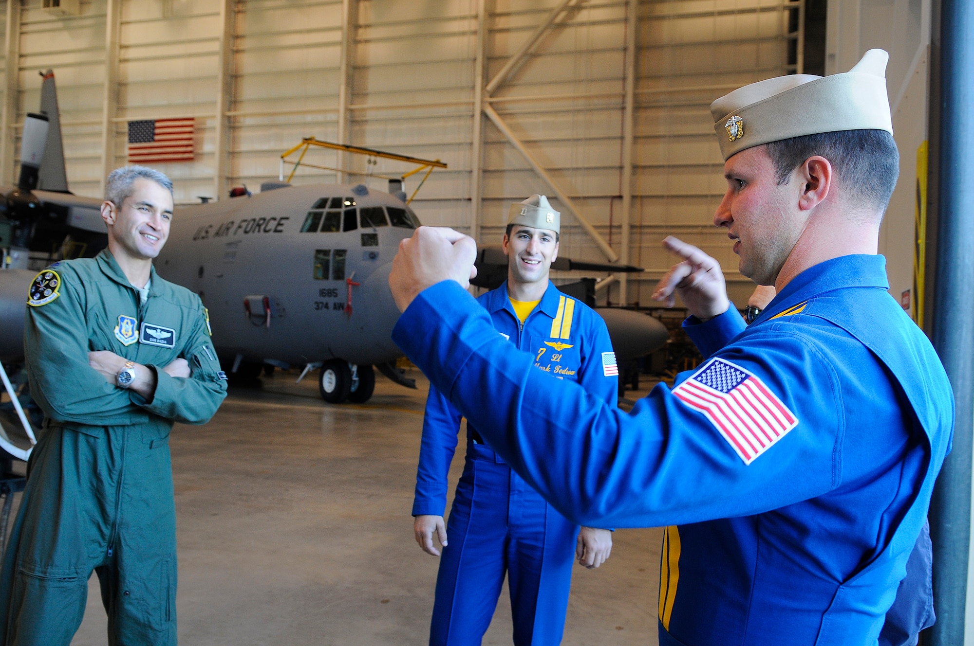 Lt. Col. Dan Badia talks with Lt. Mark Tedrow and Lt. Cmdr. Todd Royles in a hangar on Robins flightline about the requirements for housing the Blue Angels while they are here for the air show in April. (U. S. Air Force photo by Sue Sapp)

