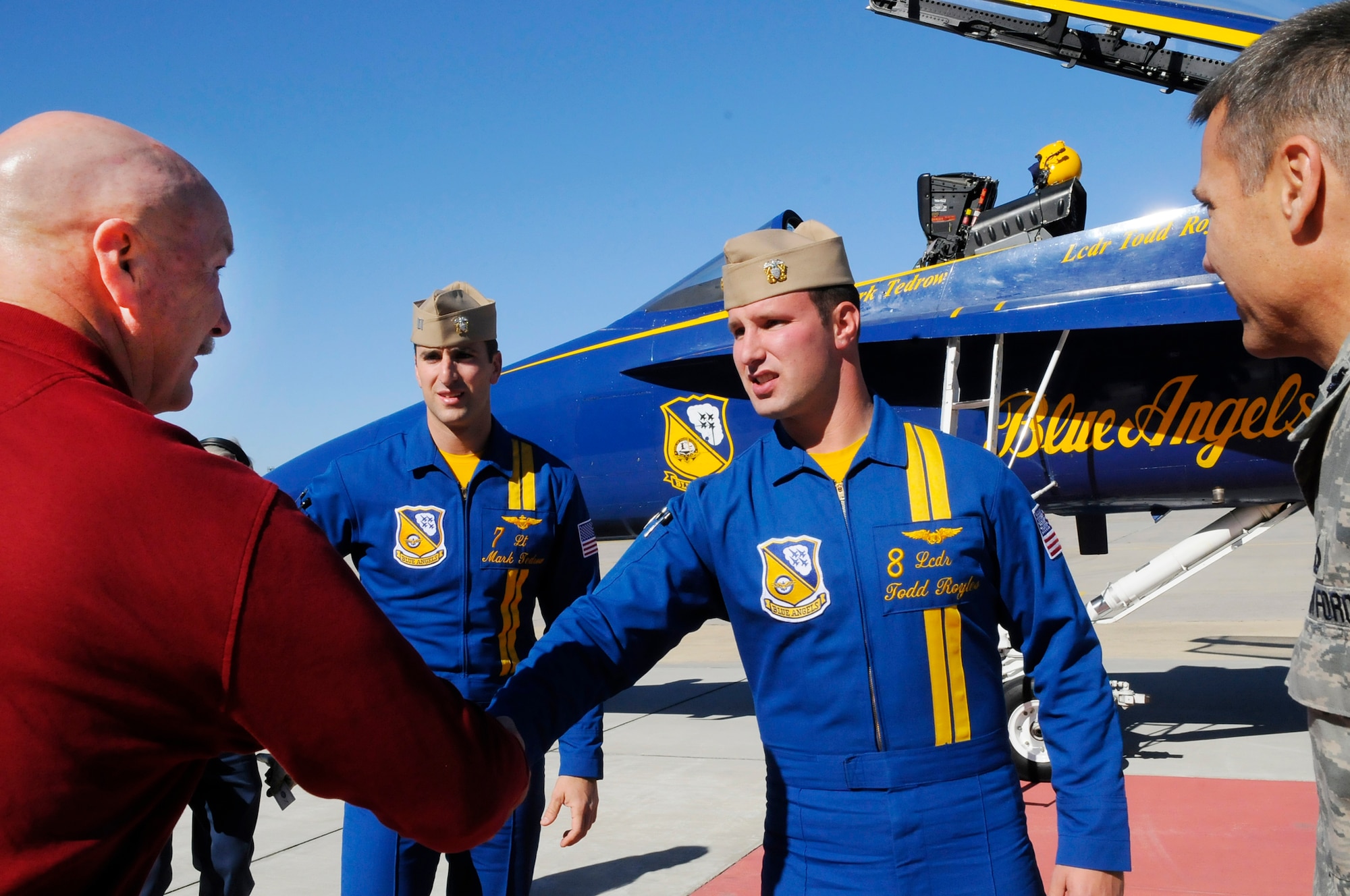 Lt. Mark Tedrow and Lt. Cmdr. Todd Royles are greeted on Robins flight line by Clyde Byrd, airfield manager and Lt. Col. Dwayne Gray, air show director Nov 18. The Blue Angels representatives visited Robins for briefings and a tour of facilities in preparation for the air show here in April. (U. S. Air Force photo by Sue Sapp)
