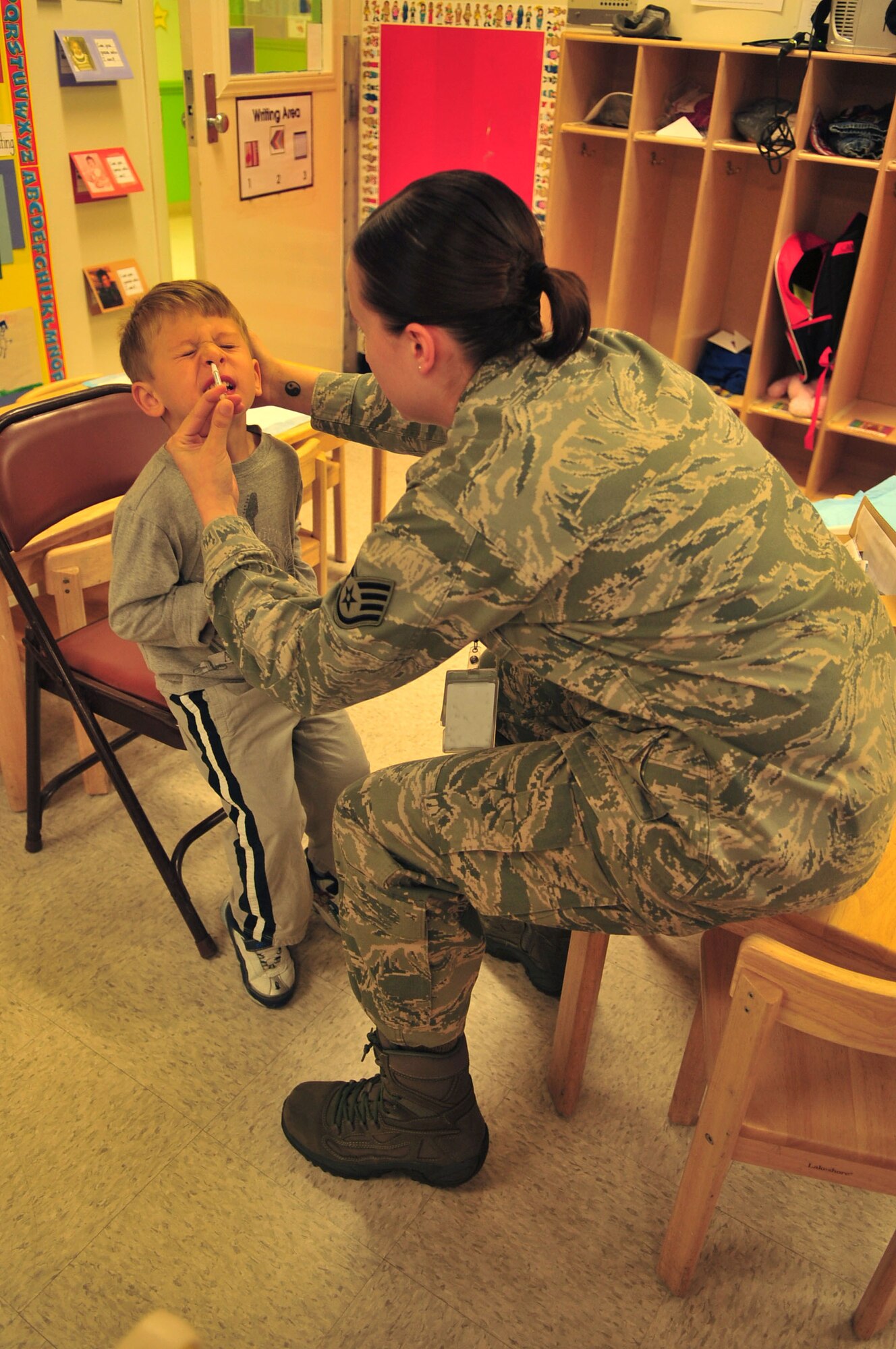 Kellen Graham cringes as he receives a FluMist vaccine from Staff Sgt. Vanessa Dale at the Child Development Center at Seymour Johnson Air Force Base, N.C., Nov. 17, 2011. The FluMist is the primary vaccine given to servicemembers and dependents between the ages of 2 and 49 with no chronic health issues. It is administered through the nasal cavity to help build antibodies to the flu virus. Kellen, 3, is the son of Maj. Nick Graham, 4th Operations Support Squadron air defense officer and Dale is a 4th Medical Support Squadron mental health technician from Newton, New Jersey. (U.S. Air Force photo by Senior Airman Marissa Tucker)  