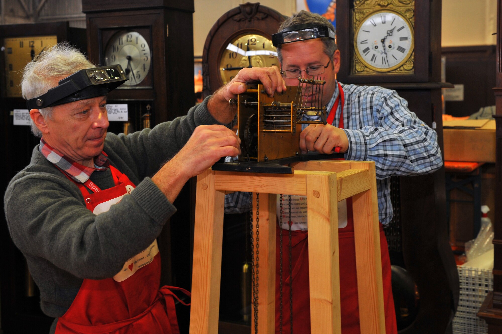 SPANGDAHLEM AIR BASE, Germany – Gerold Kraemer, left, and Eric Christeson, Clockworld clocksmiths, repair a grandfather clock at the fall bazaar here Nov. 18. The Officer and Civilian Spouses Club hosts the bazaar annually, allowing vendors from across Europe to share their products with military members and their families. These products included foodstuffs, furniture and traditional German décor. (U.S. Air Force photo/Airman 1st Class Dillon Davis)