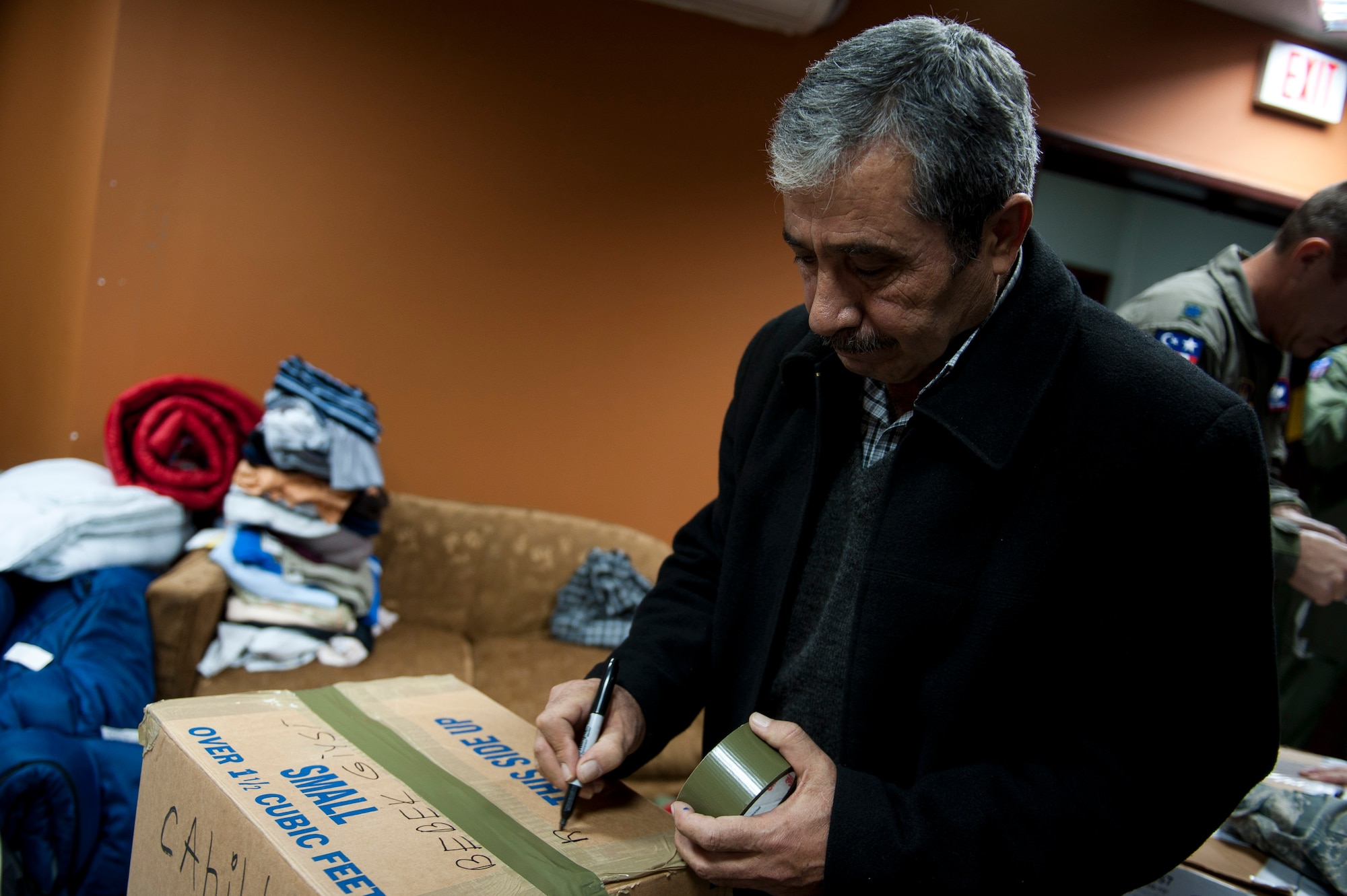 Mehmet Asikbekiroglu, a local business owner, marks supply boxes for Turkish earthquake victims with Turkish and English labels Nov. 18, 2011, at Incirlik Air Base, Turkey. On Oct. 23, a 7.2-magnitude earthquake occurred near Van, Turkey, killing more than 600 and injuring more than 1,000. The 39th Air Base Wing chapel coordinated the collection of basic hygiene items, winter clothing and footwear donated to the Turkish Red Crescent for those affected. (U.S. Air Force photo by Tech. Sgt. Michael B. Keller/Released)