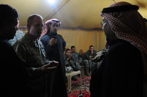 386th Air Expeditionary Wing Commander Col. Michael Zick gives coins to the locals camping outside of the base at an undisclosed location in Southwest Asia. (U.S. Air Force photo by Staff Sgt. Peter Ising)