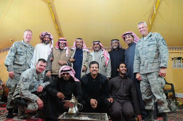 386th Air Expeditionary Wing Commander Col. Michael Zick, 386th AEW Command Chief, Chief Master Sgt. Mitchell Balutski, and 386th Expeditionary Security Force Squadron, Viper 1 NCO  in charge Tech. Sgt. Robert Daniel, gather for a group photo with locals camping outside of the base at an undisclosed location in Southwest Asia. (U.S. Air Force photo by Staff Sgt. Peter Ising)