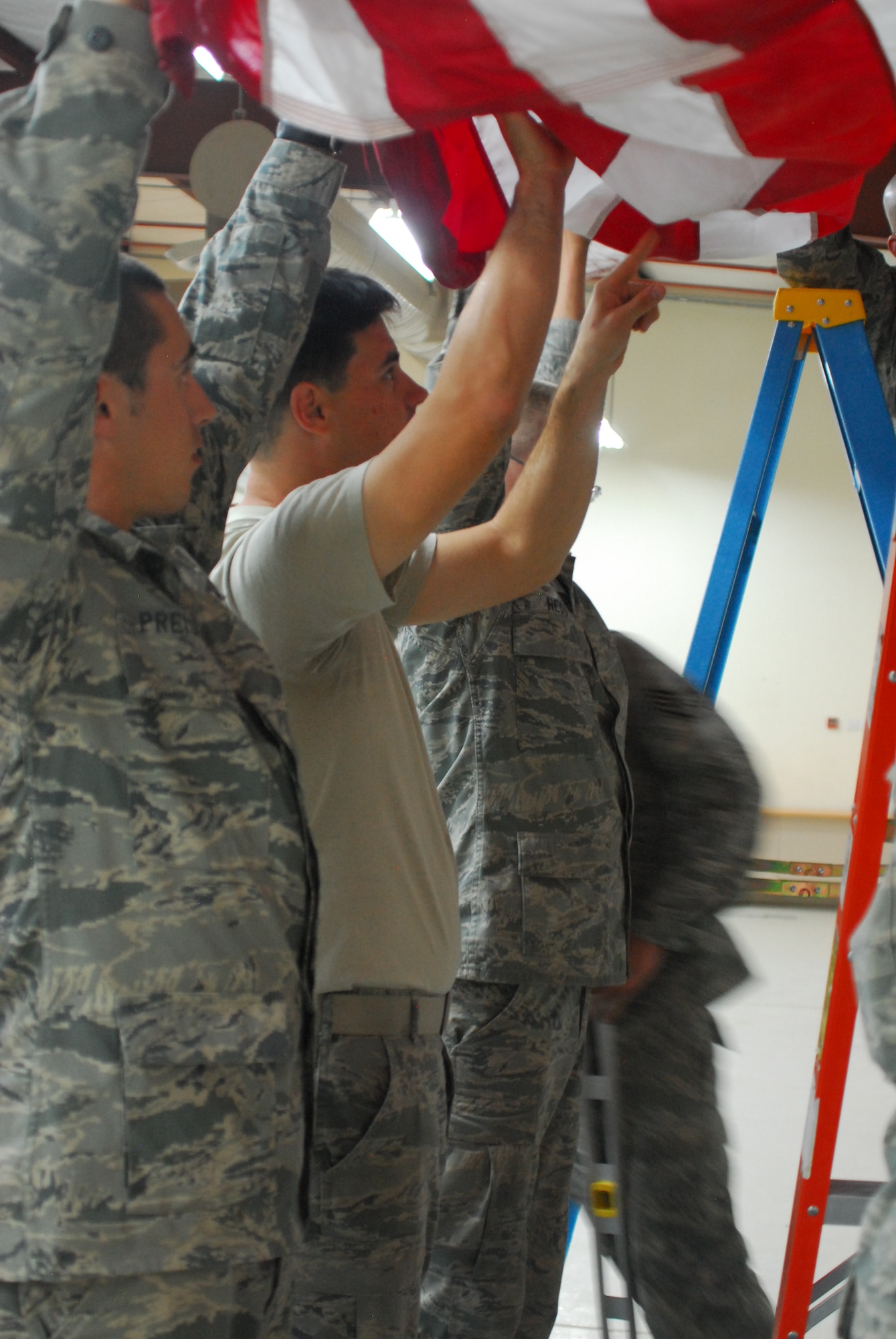 Airmen assigned to the 332nd Expeditionary Civil Engineer Squadron prepare to hang the American flag Nov. 15, 2011, at an undisclosed location in Southwest Asia in preparation for Chief of Staff of the Air Force Gen. Norton Schwartz's visit. The Chief of Staff addressed Airmen of the 332nd AEW Nov. 18, 2011, at an all call and discussed current Air Force issues. (U.S. Air Force photo by 1st Lt. Rusty Ridley)