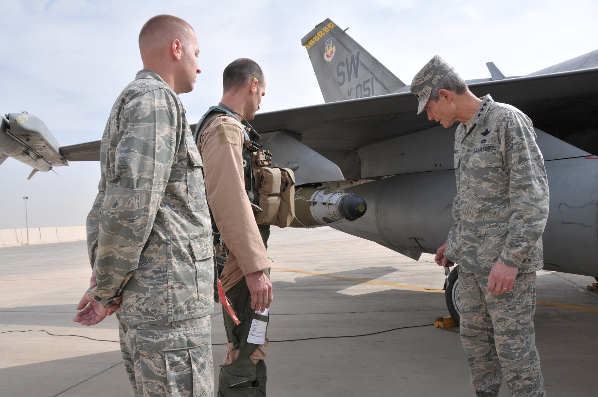 First Lt. Bernard Conrad, 332nd Expeditionary Aircraft Maintenance Squadron, and Maj. James Buessing, 79th Expeditionary Fighter Squadron, give Air Force Chief of Staff Gen. Norton Schwartz a close-up look at a Guided Bomb Unit-54 Laser/GPS guided munition attached to an F-16 Fighting Falcon at an undisclosed location in Southwest Asia Nov. 18, 2011. (U.S. Air Force photo/Master Sgt. Paul Mann)