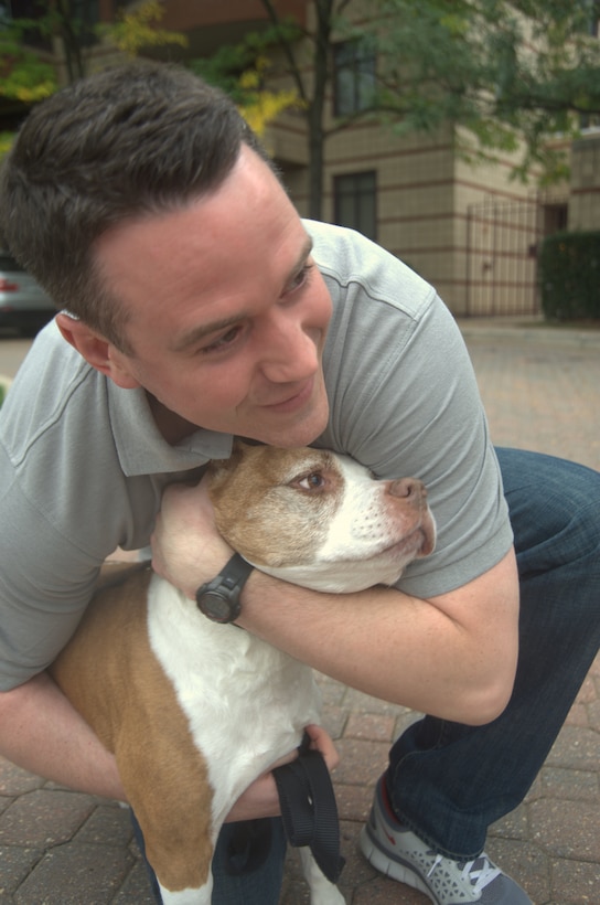 Former Air Force Senior Airman David Sharpe embraces his dog, Cheyenne, at their home in Arlington, Va., Sept. 22, 2011. Sharpe is the founder of Pets 2 Vets, a nonprofit organization that pairs shelter animals with veterans who live with post-traumatic stress disorder. Sharpe credits Cheyenne with saving his life. U.S. Air Force photo by Tech. Sgt. Mareshah Haynes