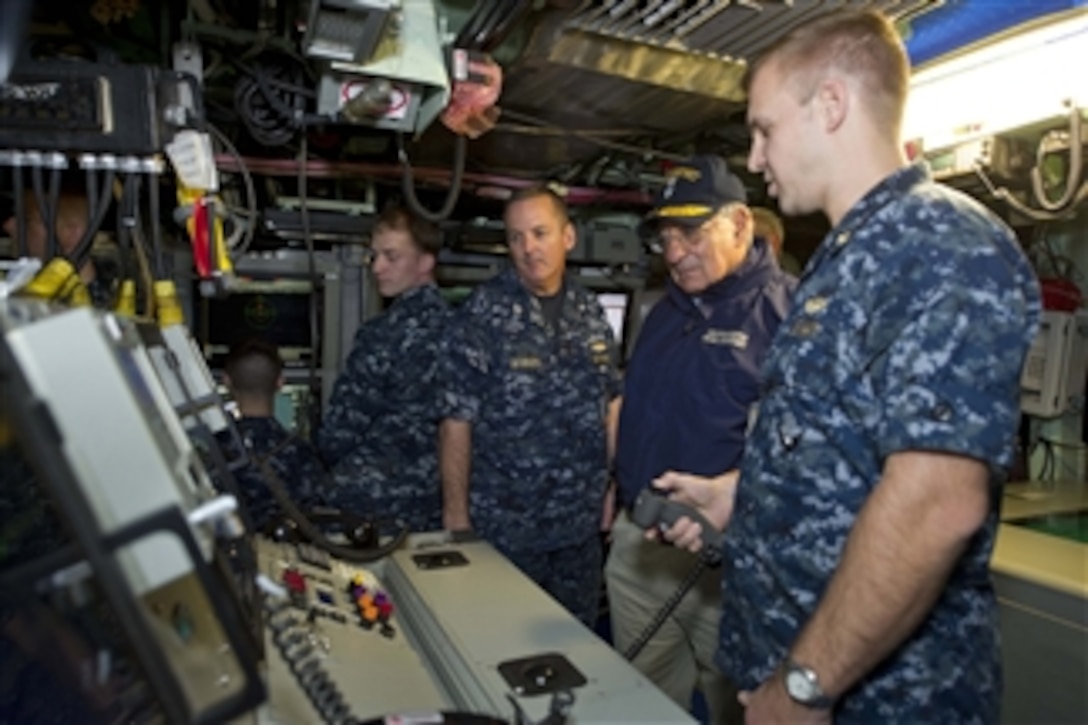 Secretary of Defense Leon E. Panetta watches as an officer from the USS Mississippi demonstrates a piece of equipment aboard the submarine in Groton, Ct. on November 17, 2011.  