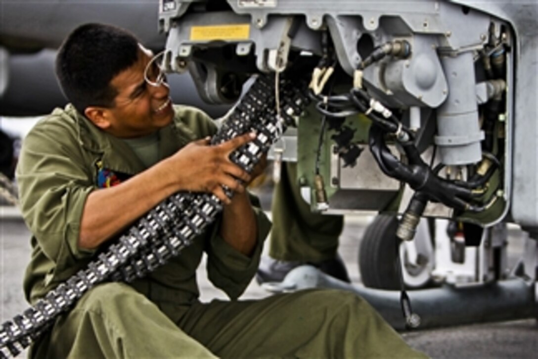 U.S. Marine Corps Cpl. Ceasar Vargas installs a link less feed system onto an AH-1Z Super Cobra helicopter aboard the USS Makin Island underway in the Pacific Ocean on Nov. 16, 2011.  Vargas is an aviation ordnanceman assigned to Marine Medium Helicopter Squadron 268.  