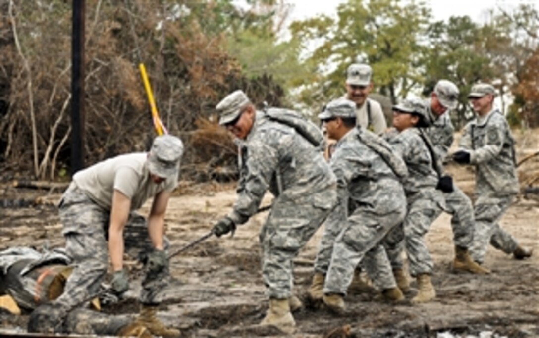 Soldiers assigned to the 436th Chemical Detachment help clean up debris from the wildfires in Bastrop, Texas, Nov. 19, 2011.