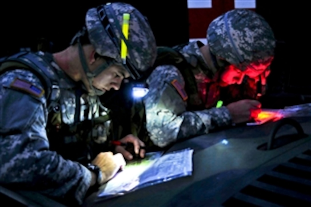 U.S. Army Cpt. Nick Franck, left, and 2nd Lt. Charles Smith, right, plot their points on maps for the day-to-night land navigaton course during the U.S. Army Europe Best Junior Officer Competition on U.S. Army Garrison Grafenwoehr in Germany, Nov. 16, 2011. Franck is assigned to the 12th Combat Aviation Brigade, and Smith is assigned to the 18th Engineer Brigade.