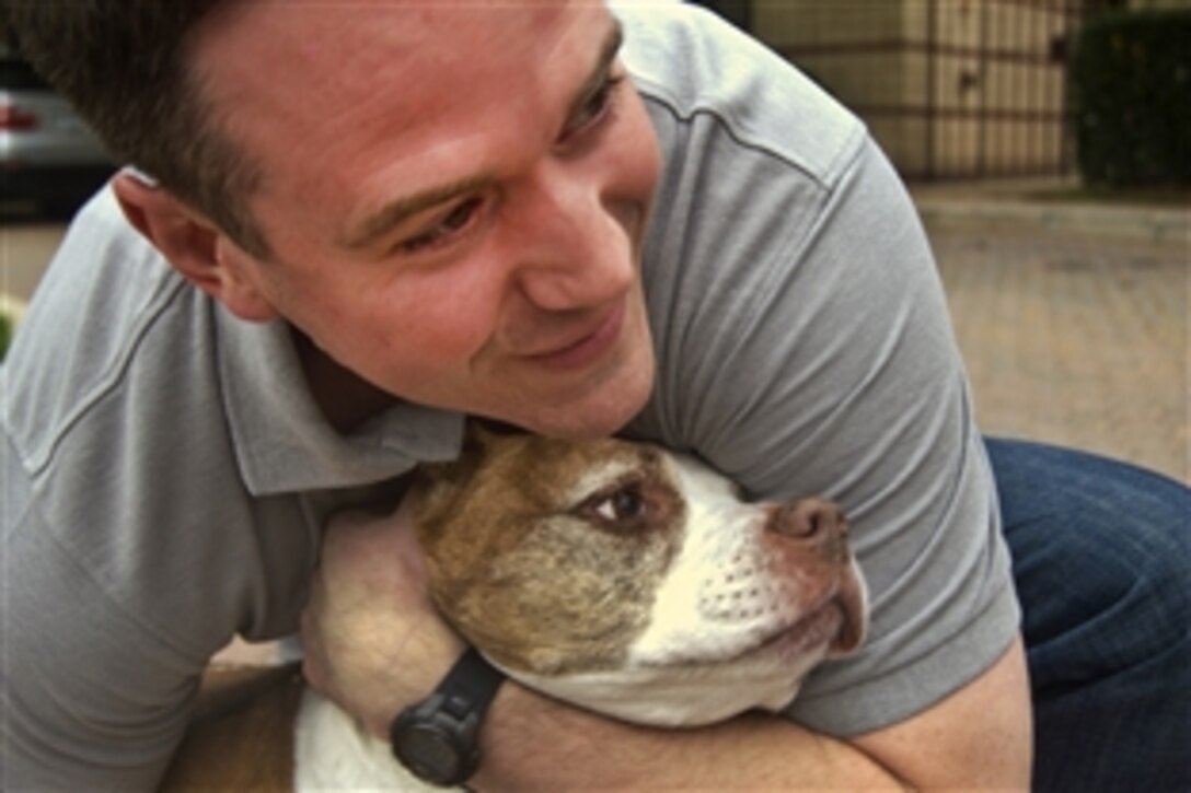 Former Air Force Senior Airman David Sharpe embraces his dog, Cheyenne, at their home in Arlington, Va., Sept. 22, 2011. Sharpe is the founder of Pets 2 Vets, a nonprofit organization that pairs shelter animals with veterans who live with post-traumatic stress disorder. Sharpe credits Cheyenne with saving his life.