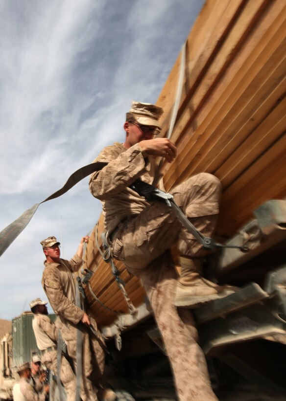Cpl. Aaron Raley, of Rome, Ga., removes a ratchet strap from a stack of lumber at Patrol Base New York, Afghanistan, Nov. 22. Raley is a motor transportation operator with Combat Logistics Company 6, 2nd Marine Logistics Group (Forward). The company, which is comprised of two engineer platoons and one motor transportation platoon, is an element of Combat Logistics Battalion 6 and was formed to provide direct support to 1st Battalion, 6th Marine Regiment, during Operation Eastern Storm. (U.S. Marine Corps photo by Sgt. Justin J. Shemanski)
