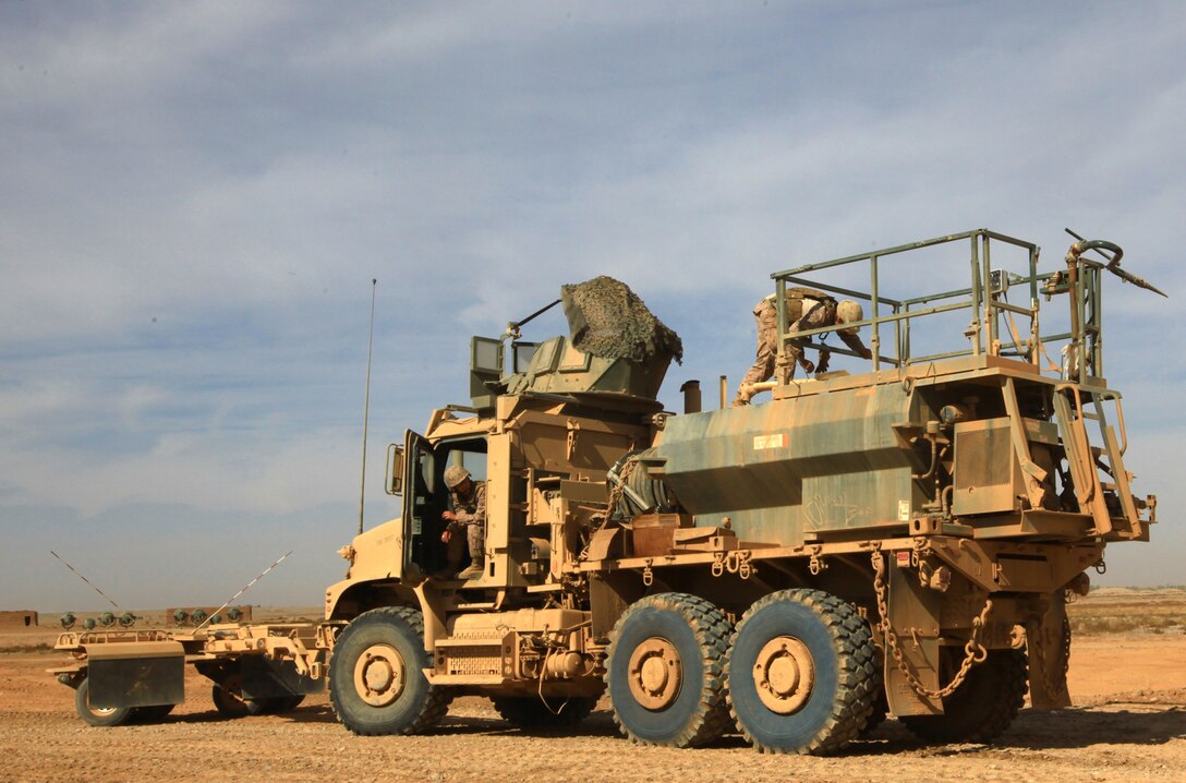 A construction vehicle belonging to 9th Engineer Support Battalion, 2nd Marine Logistics Group (Forward), sprays down a road during an operation in Helmand province, Afghanistan, in late 2011. The Marines spent multiple days building a main supply route in the Shir Ghazay area. (U.S. Marine Corps photo by Cpl. Katherine M. Solano)