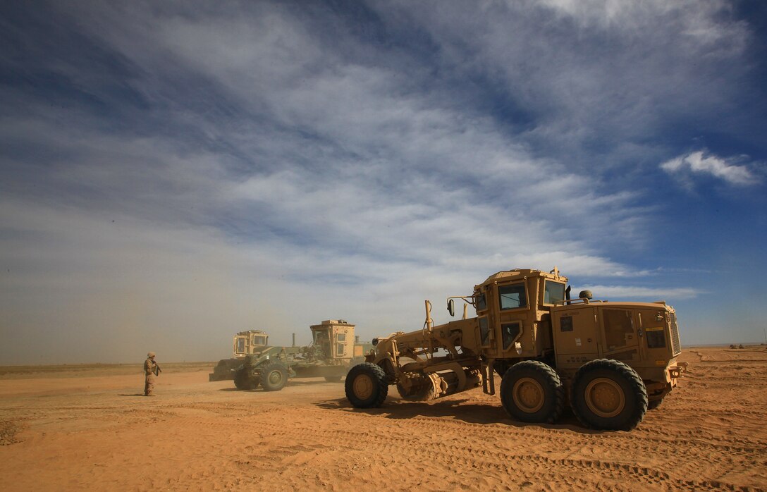 Construction vehicles belonging to 9th Engineer Support Battalion, 2nd Marine Logistics Group (Forward), are paused during a break in route construction in Helmand province, Afghanistan, in late 2011. Marines spent multiple days building a route to provide safe travel for coalition forces and local Afghans in the Shir Ghazay area. (U.S. Marine Corps photo by Cpl. Katherine M. Solano)