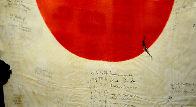 The Japanese Imperial flag, signed by members of the Fifth Marine Regiment, captured at Shuri Castle during the Battle of Okinawa, May 29,1945. The flag is part of an exhibit that has been located on Camp Kinser since 1994 and has more than 1,000 World War II artifacts on display. (U.S. Air Force photo/Staff Sgt. Christopher Hummel/Released) 

