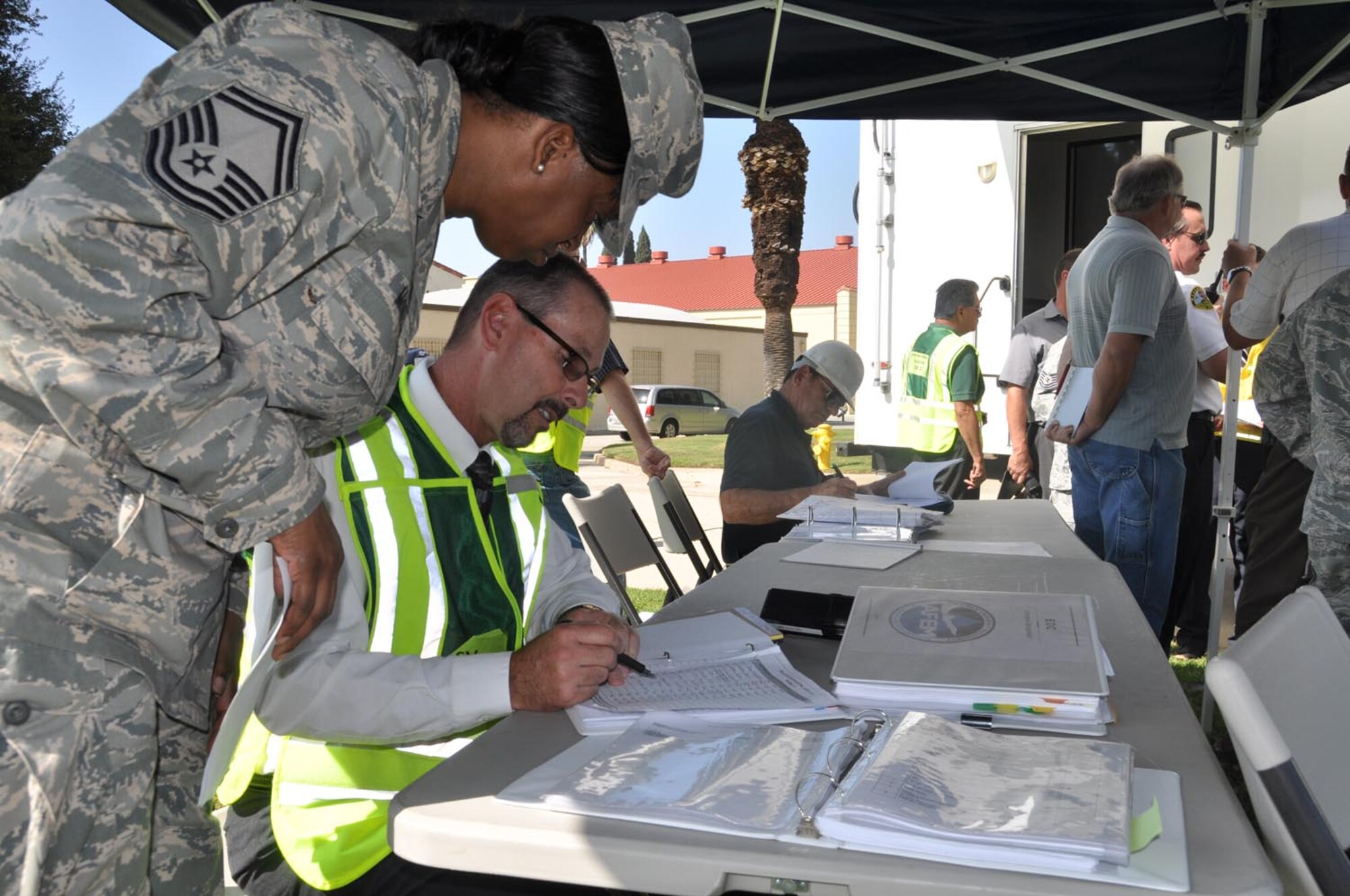 During the California-wide Great ShakeOut earthquake drill, Senior Master Sgt. Helena McGhee, 452 AMDS, compares notes with Cary Kerr, 452 FSS, in the outdoor emergency operations center at March Air Reserve Base, Calif., Oct. 20, 2011. (U.S. Air Force photos/Lt. Col. Don Traud)