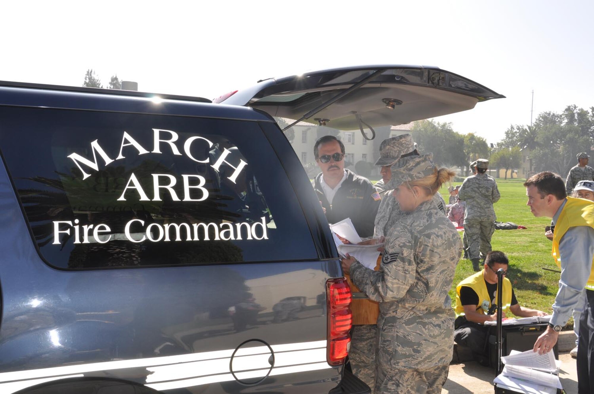 During the California-wide Great ShakeOut earthquake drill, Chief Master Sgt. Timi Levy (center), 452 AMDS, makes a report to Harold Sterne, March Fire Department, at March Air Reserve Base, Calif., Oct. 20, 2011. (U.S. Air Force photos/Lt. Col. Don Traud)