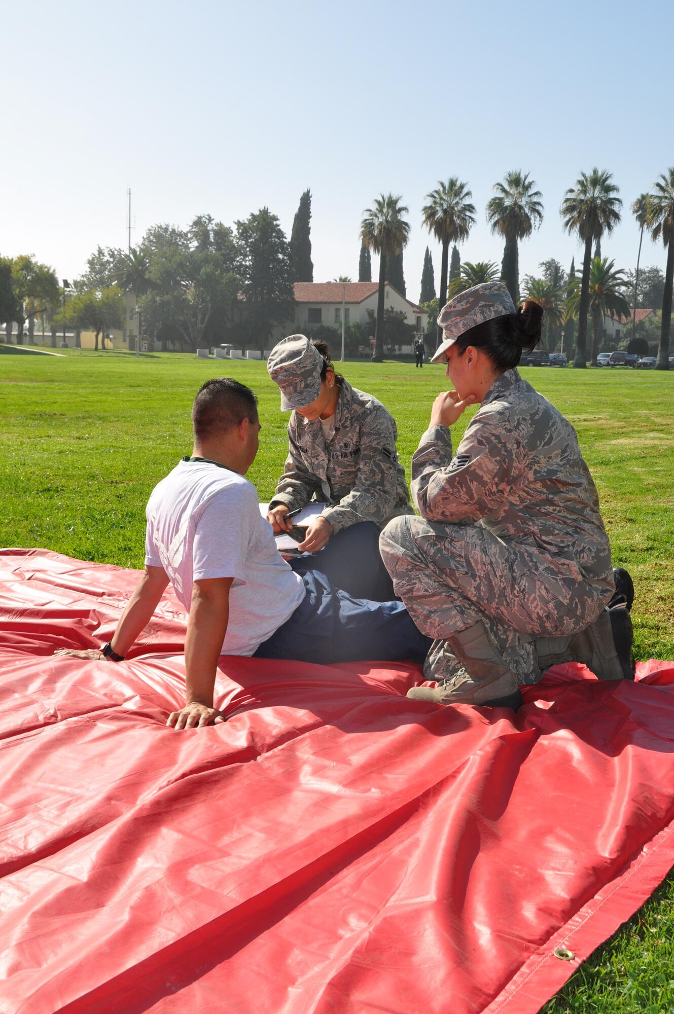 During the California-wide Great ShakeOut earthquake drill, Airman 1st Class Jennie Estrella, 452 ASTS, and Senior Airman Jennifer Navarro, 452 AMDS, assess a patient at March Air Reserve Base, Calif., Oct. 20, 2011. (U.S. Air Force photos/Lt. Col. Don Traud)