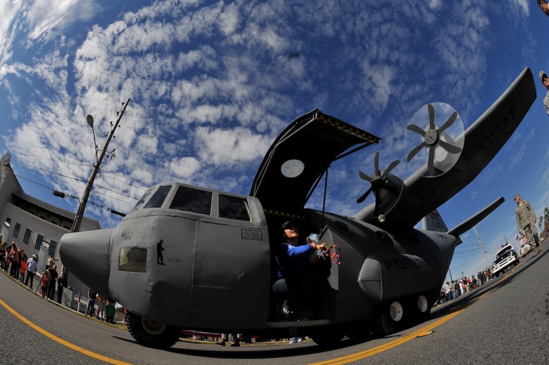 Shannon Sherman, wife of the 403rd Wing's senior recruiter, tosses candy to the crowd gathered along the parade route during the Veterans Day parade in D'Iberville, Miss. Nov. 12. (U.S. Air Force Photo by. Capt. J. Justin Pearce) 